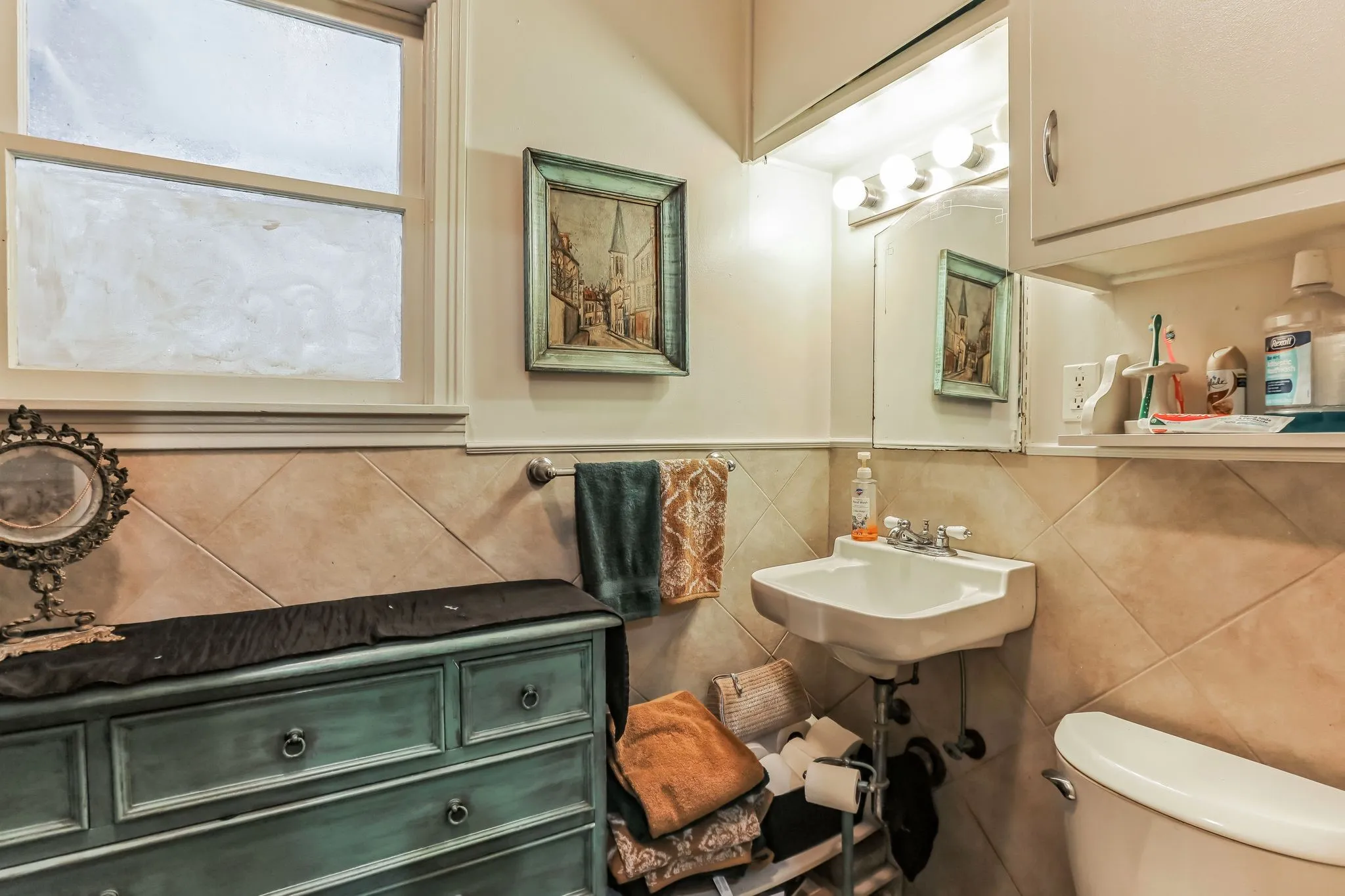 Bathroom with tile walls, a sink, and toilet