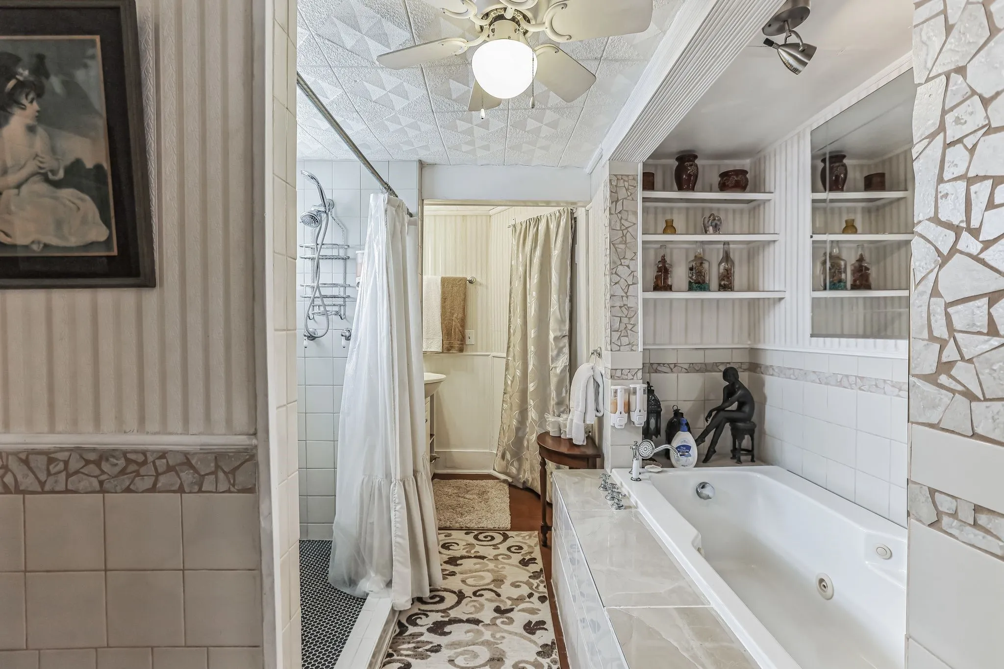 Bathroom with ceiling fan, tile walls, a tub with jets, tile patterned flooring, and a stall shower