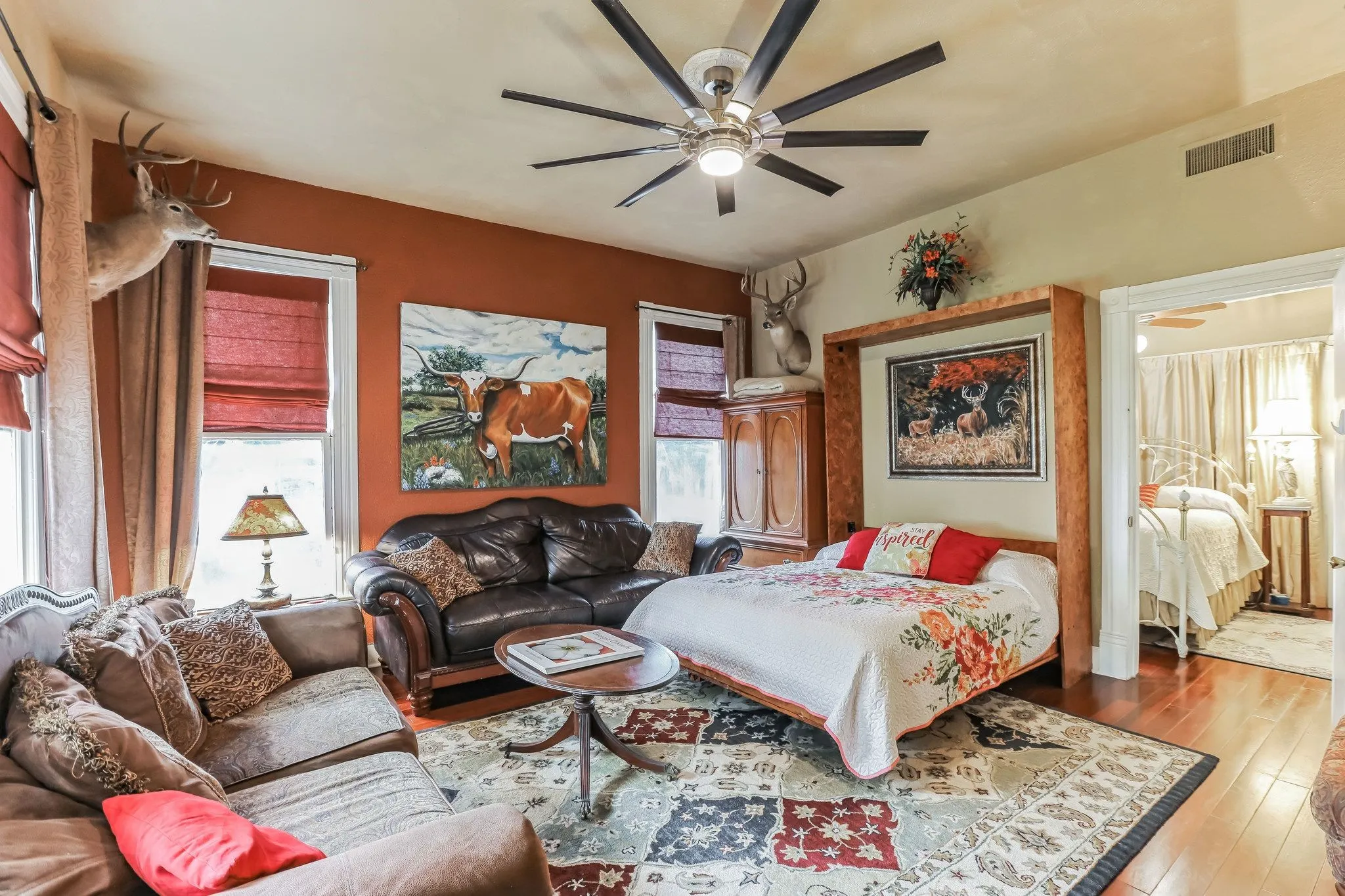 Bedroom with visible vents, hardwood / wood-style flooring, multiple windows, and a ceiling fan