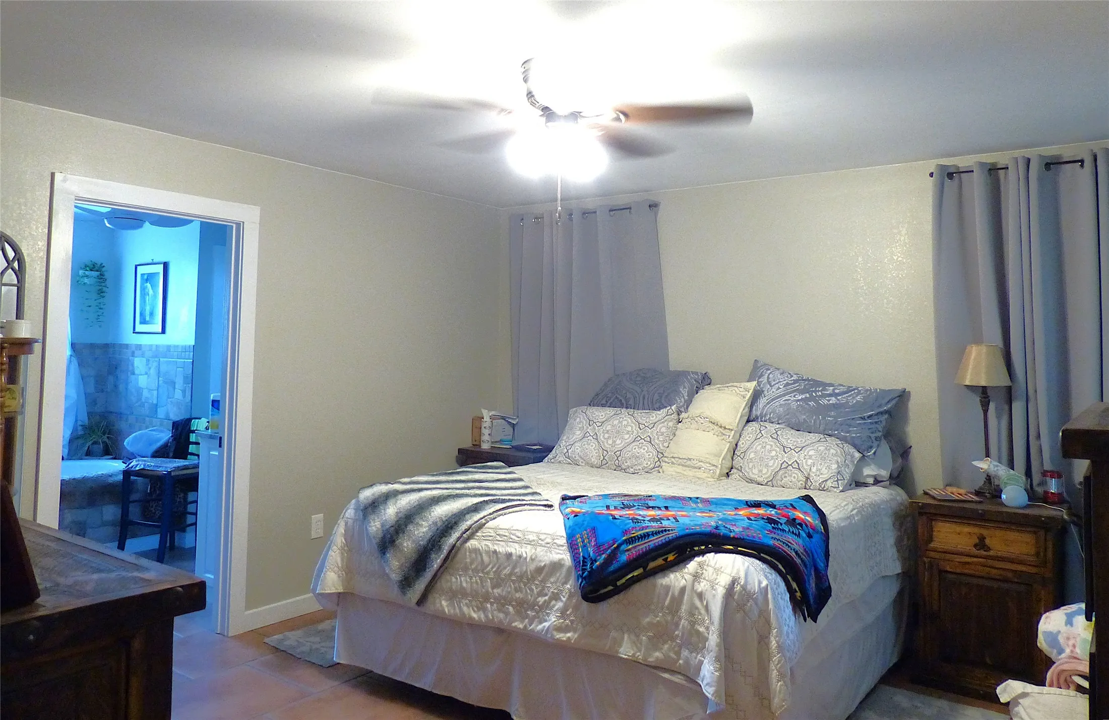 Tiled bedroom featuring ceiling fan