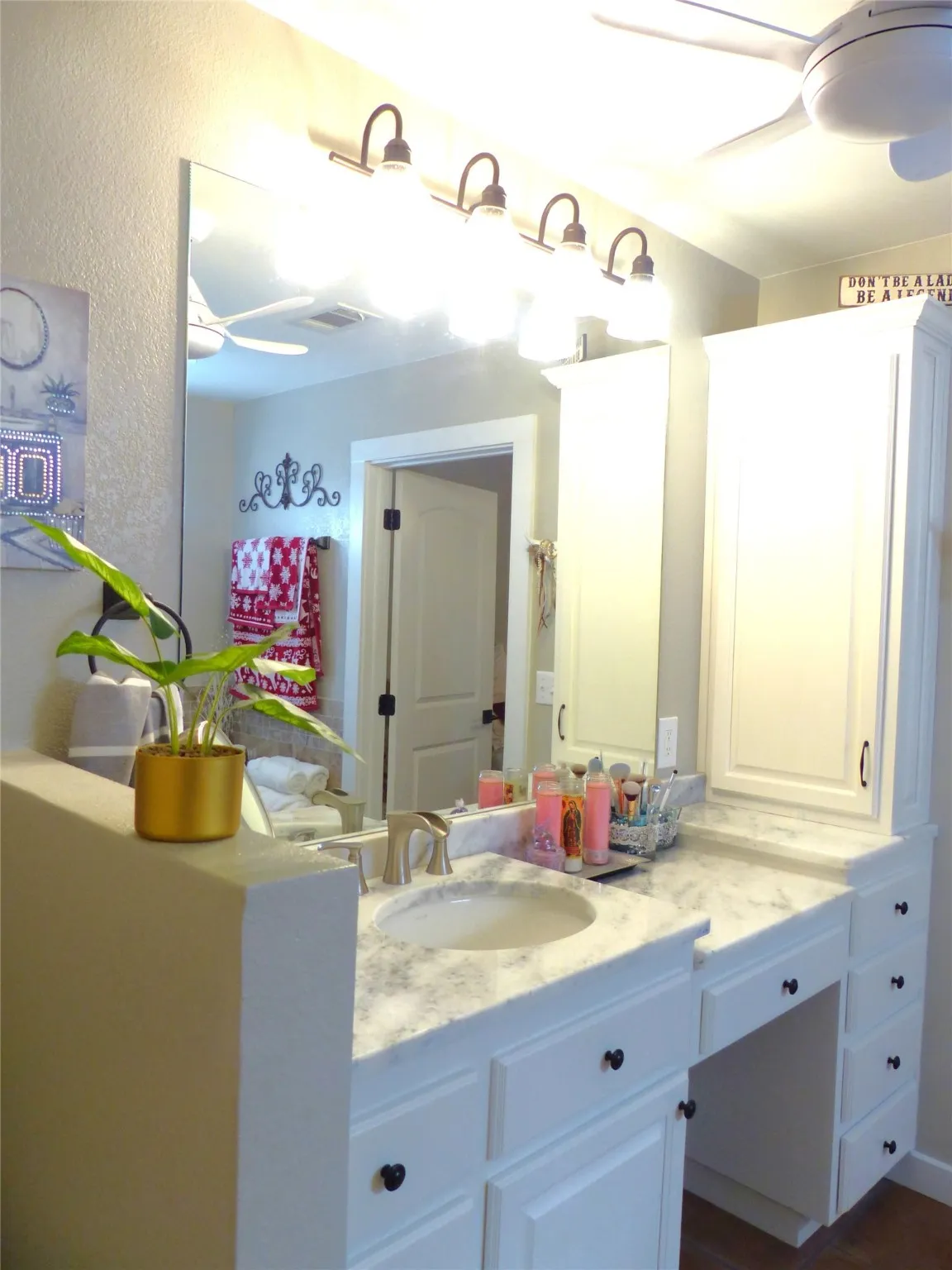 Bathroom featuring a ceiling fan, vanity, and a textured wall