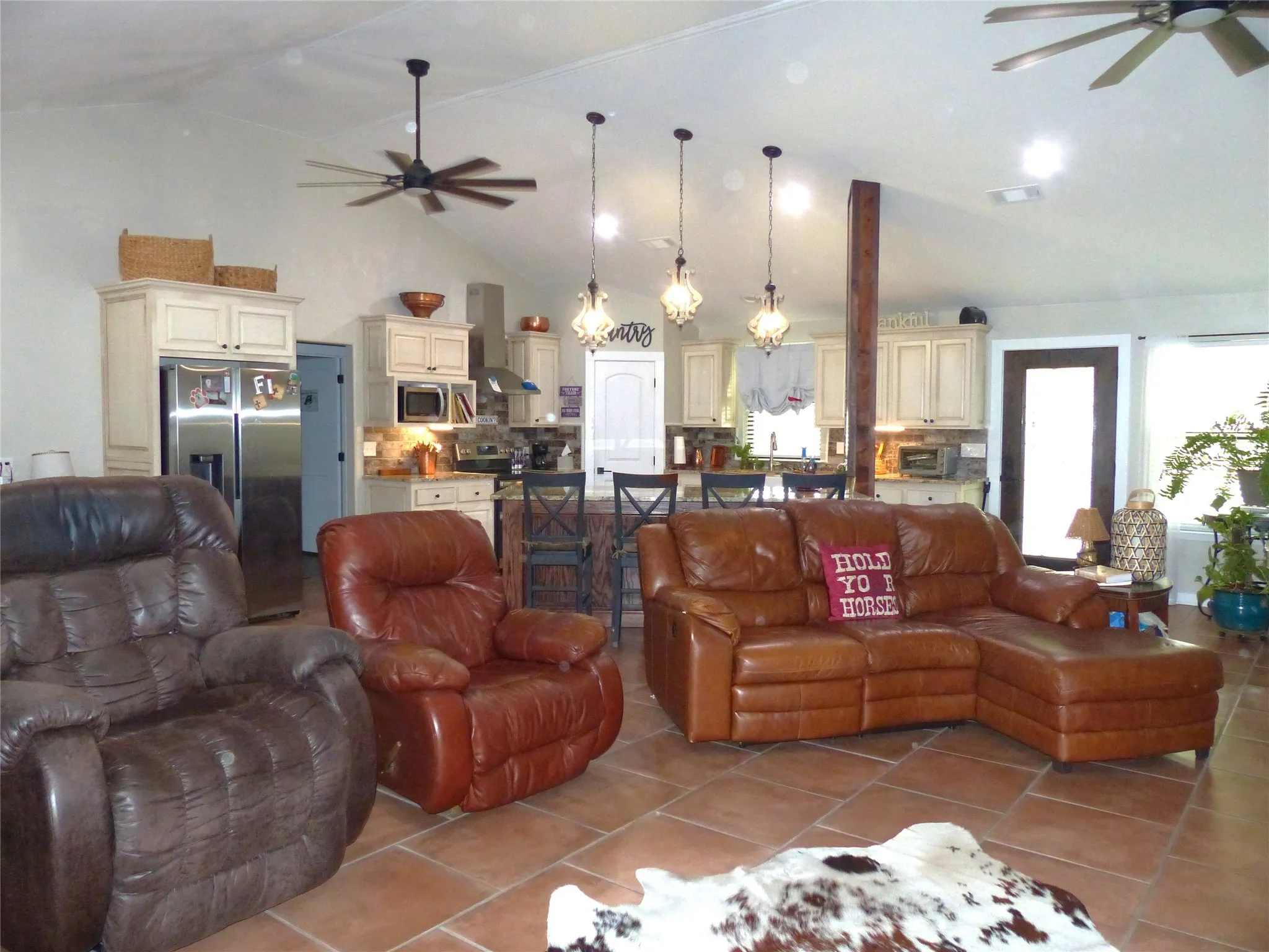 Tiled living area featuring high vaulted ceiling and a ceiling fan