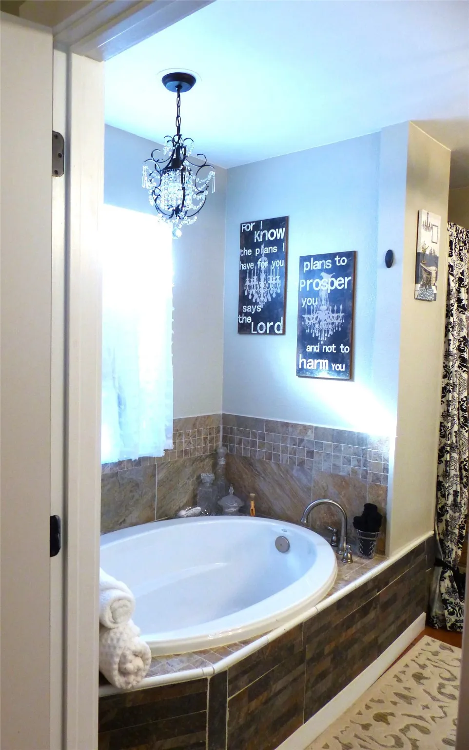 Full bathroom featuring a garden tub and a chandelier