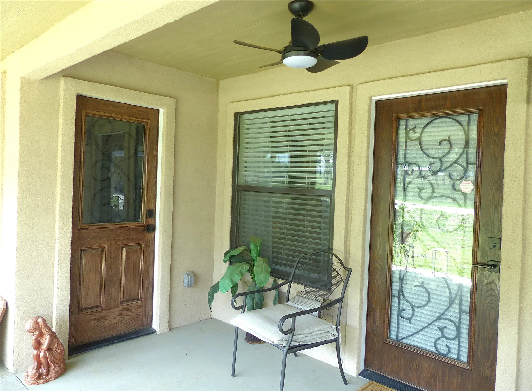 View of exterior entry featuring a ceiling fan and stucco siding