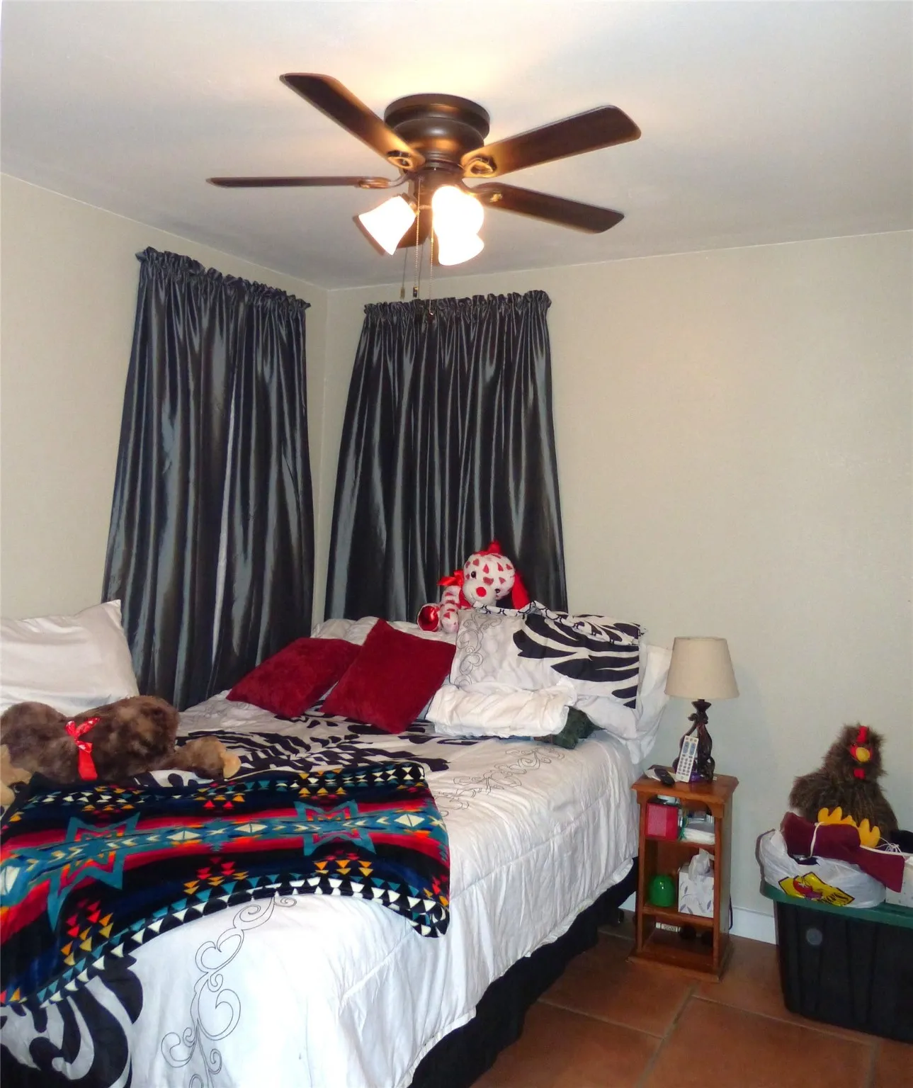 Tiled bedroom featuring ceiling fan