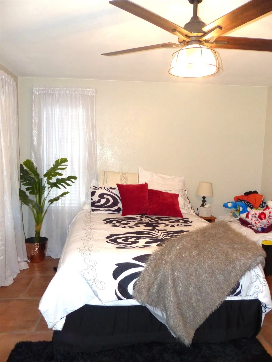 Bedroom with dark tile patterned flooring and a ceiling fan