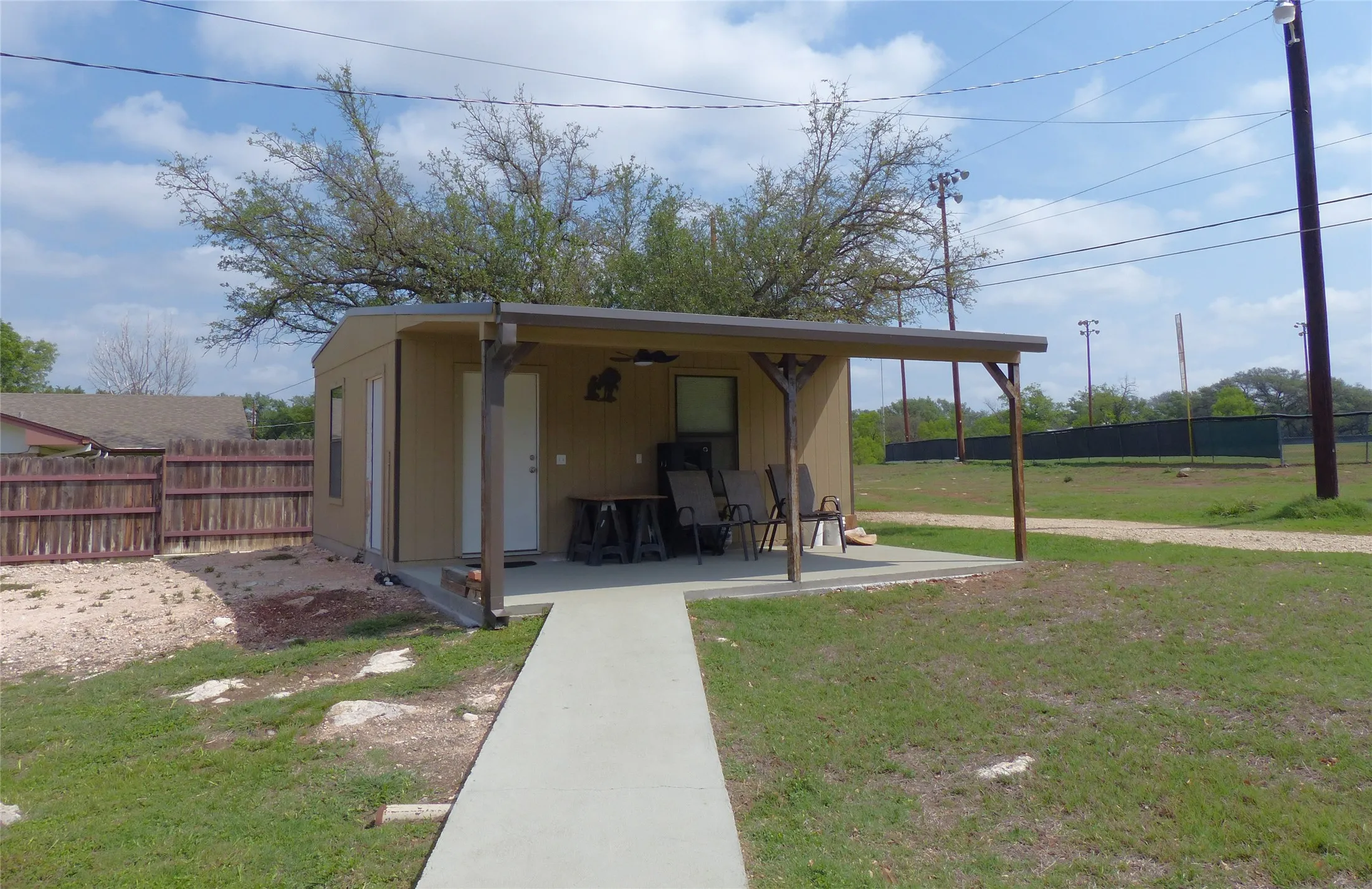 View of yard with fence, a ceiling fan, and a patio area