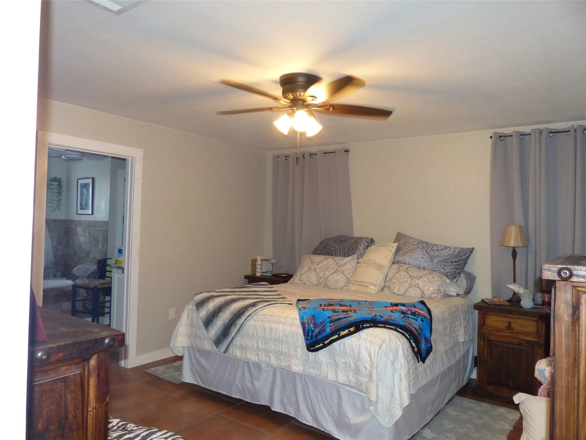 Bedroom with a ceiling fan and dark tile patterned floors