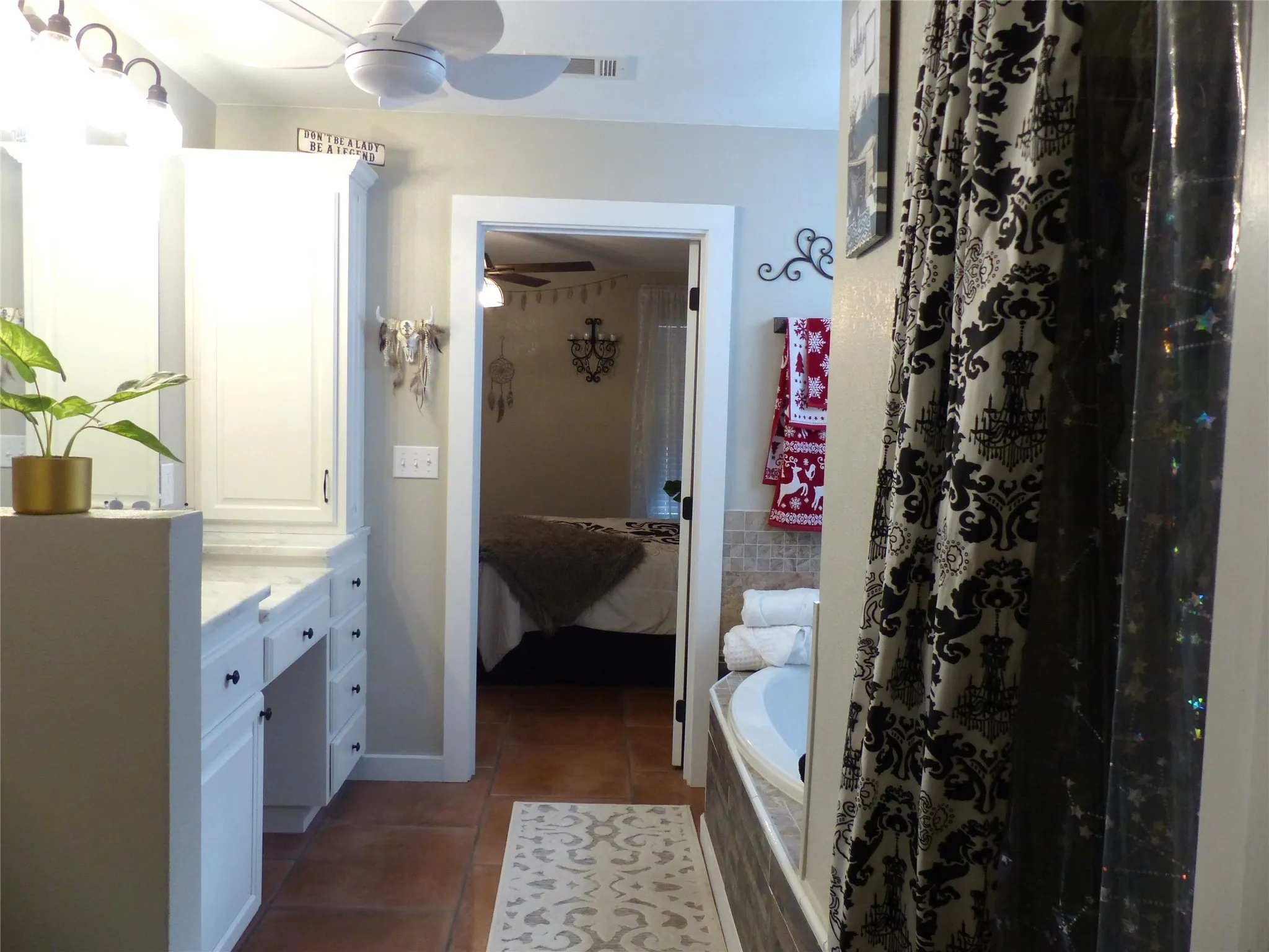Full bath featuring ensuite bath, tiled tub, a shower with curtain, dark tile patterned floors, and vanity