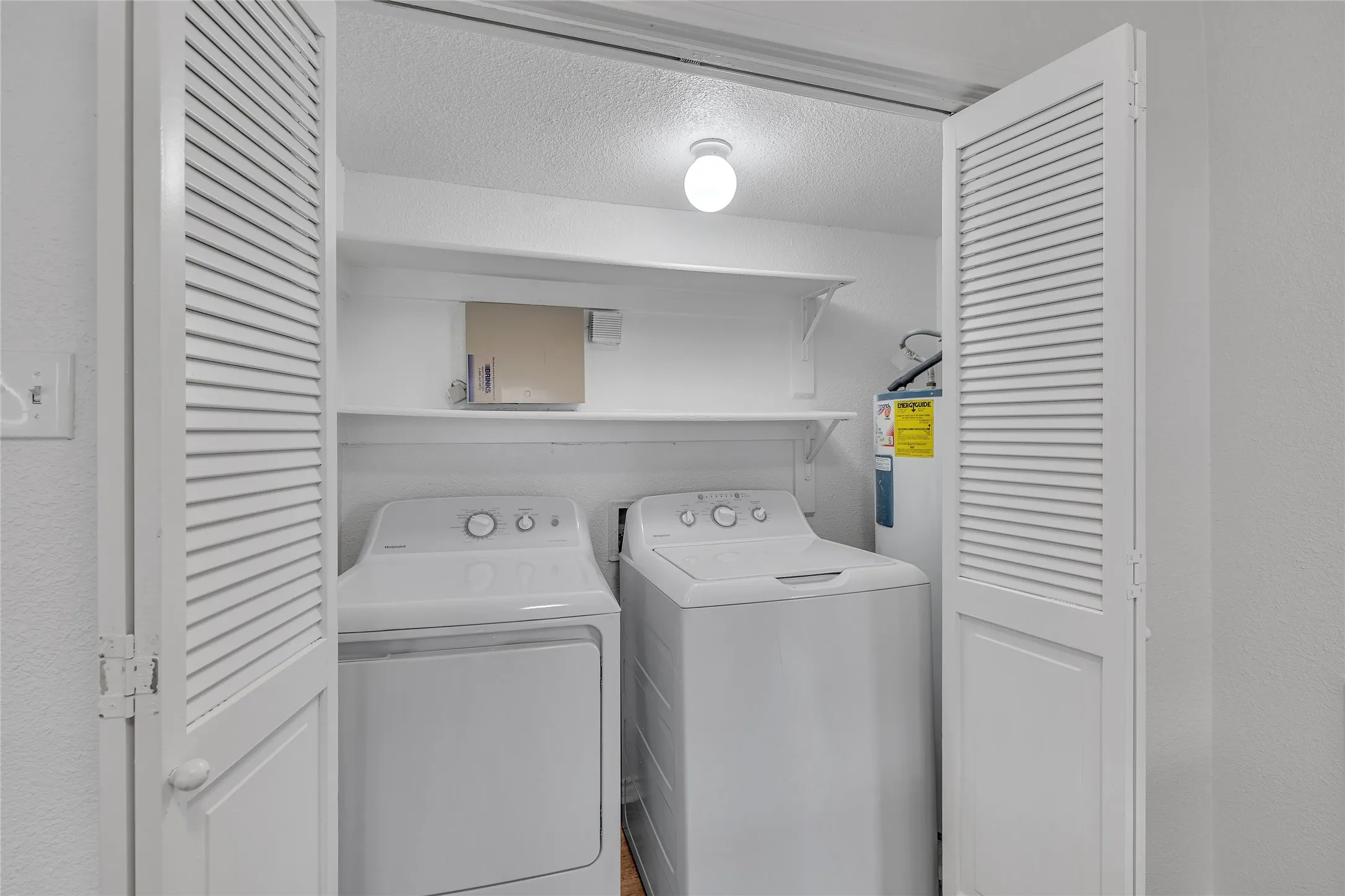 Laundry room featuring independent washer and dryer, laundry area, and a textured ceiling