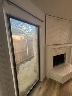 Sliding glass door opening to an outdoor area with wood fencing