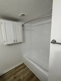Bathtub and shower combination with a curved shower rod