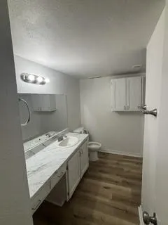 Bathroom featuring a single vanity with an integrated sink, a white countertop, and white cabinetry