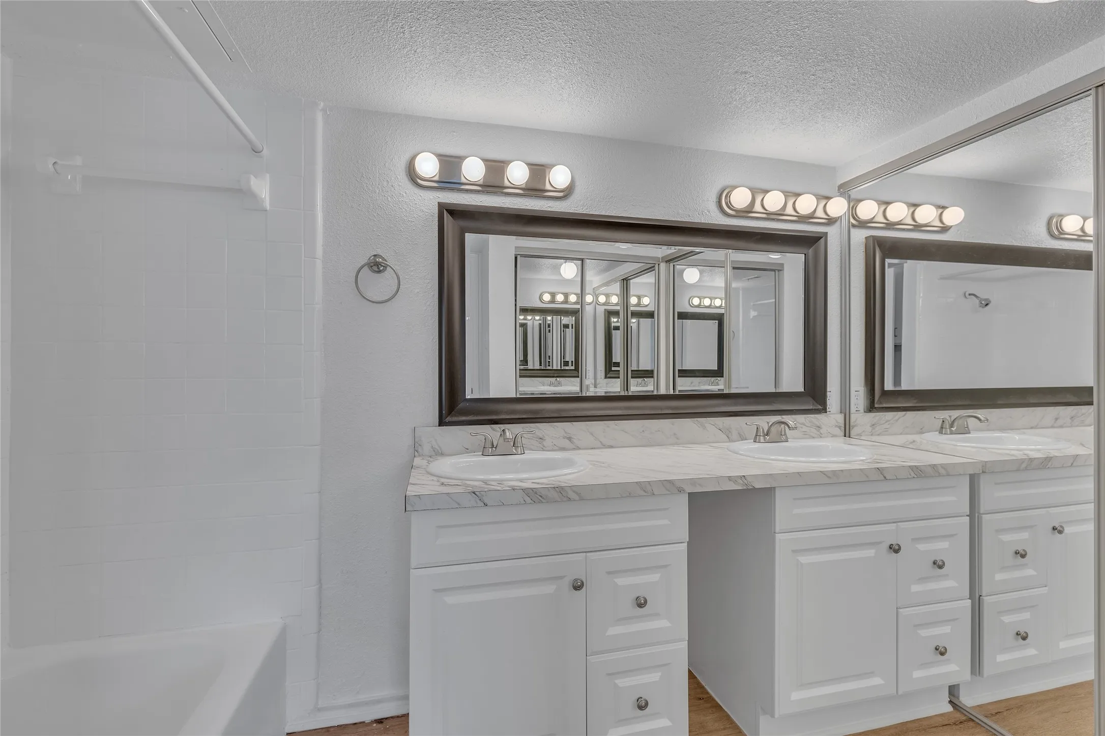 Full bathroom featuring double vanity, shower / bath combination, and a sink