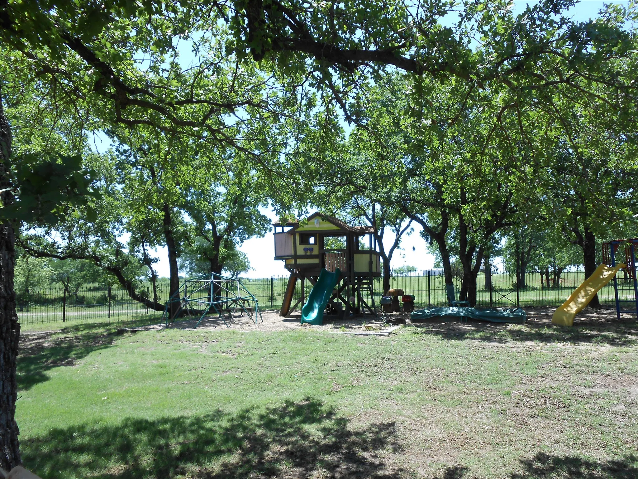 View of play area featuring fence and a yard