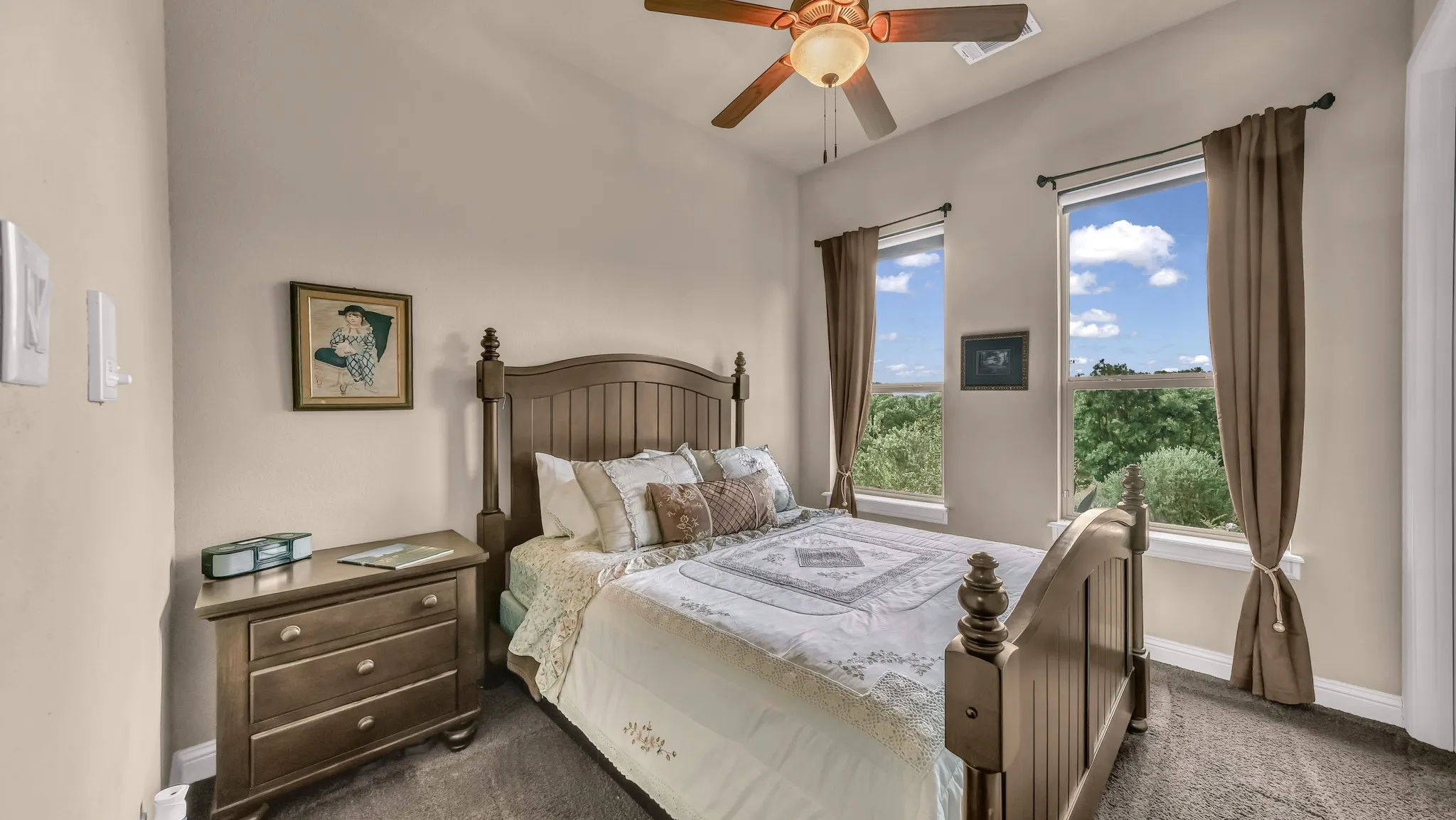Bedroom featuring dark colored carpet, baseboards, ceiling fan, and multiple windows