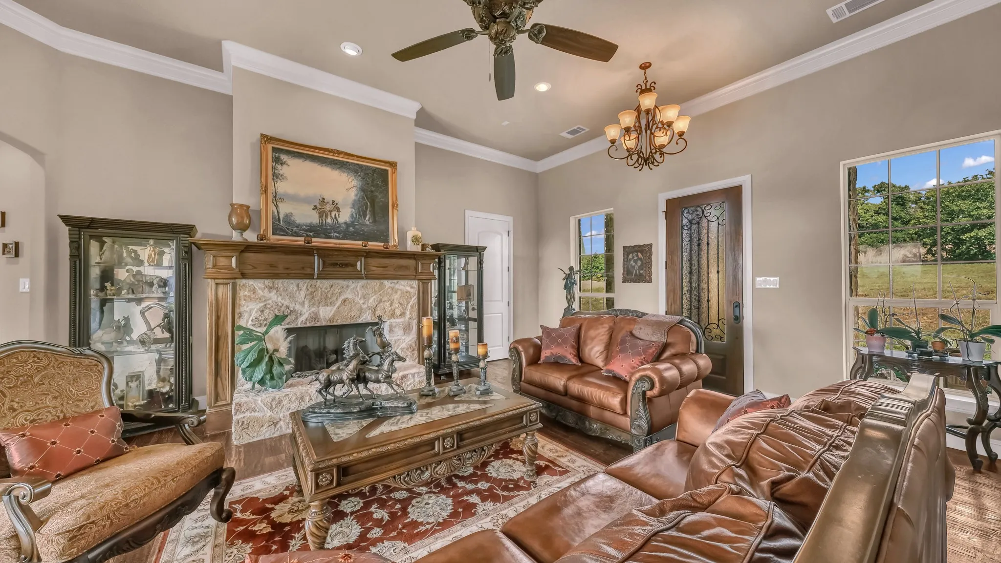 Living room with a ceiling fan, visible vents, a high end fireplace, wood finished floors, and recessed lighting