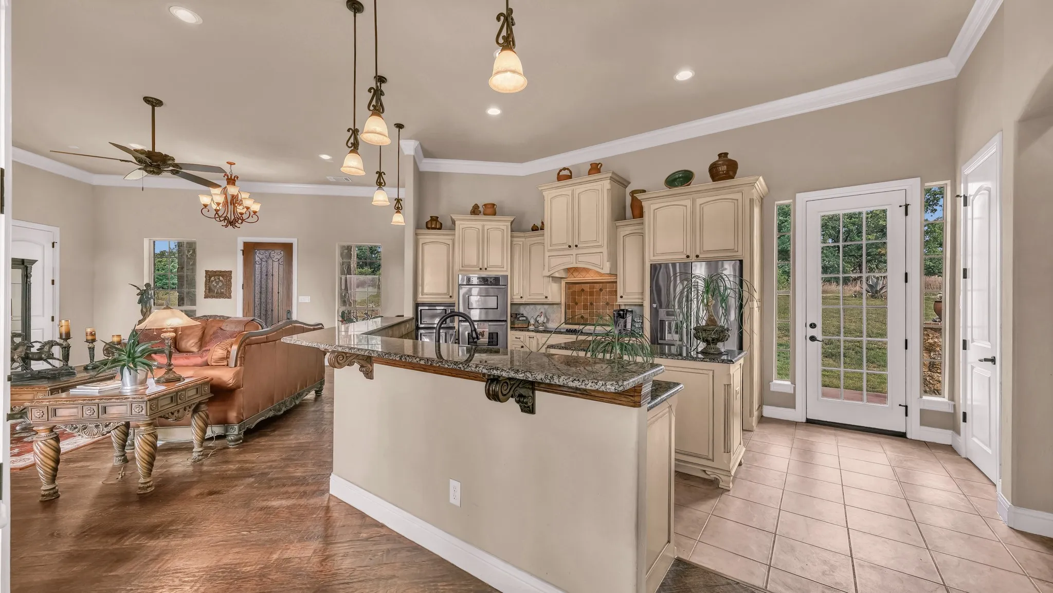 Kitchen with a center island with sink, dark stone counters, stainless steel appliances, recessed lighting, and cream cabinetry