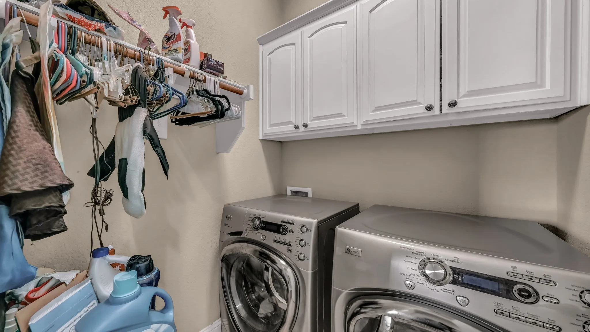 Laundry room featuring separate washer and dryer and cabinet space