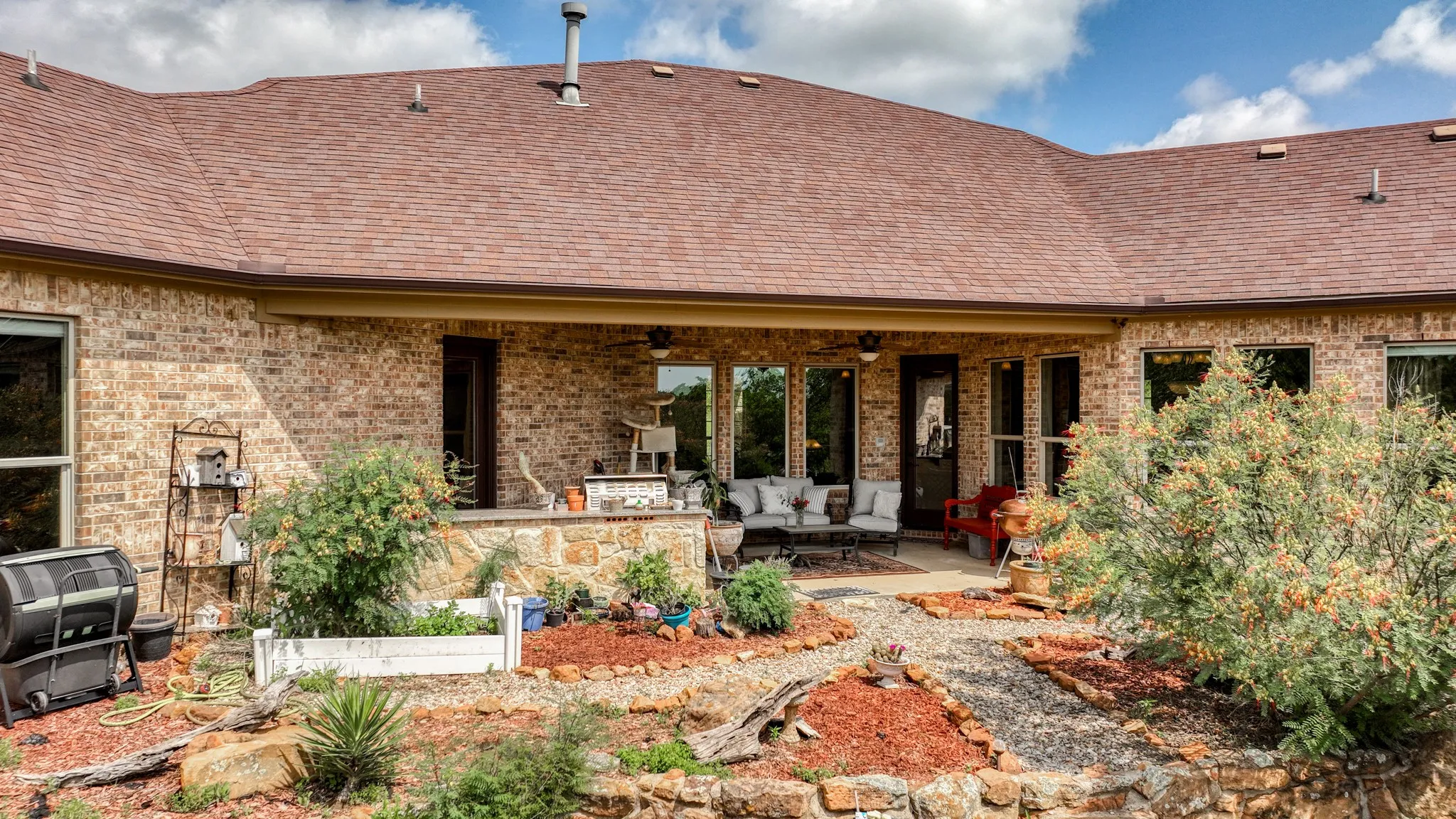 Rear view of property featuring an outdoor hangout area, a patio, ceiling fan, and brick siding