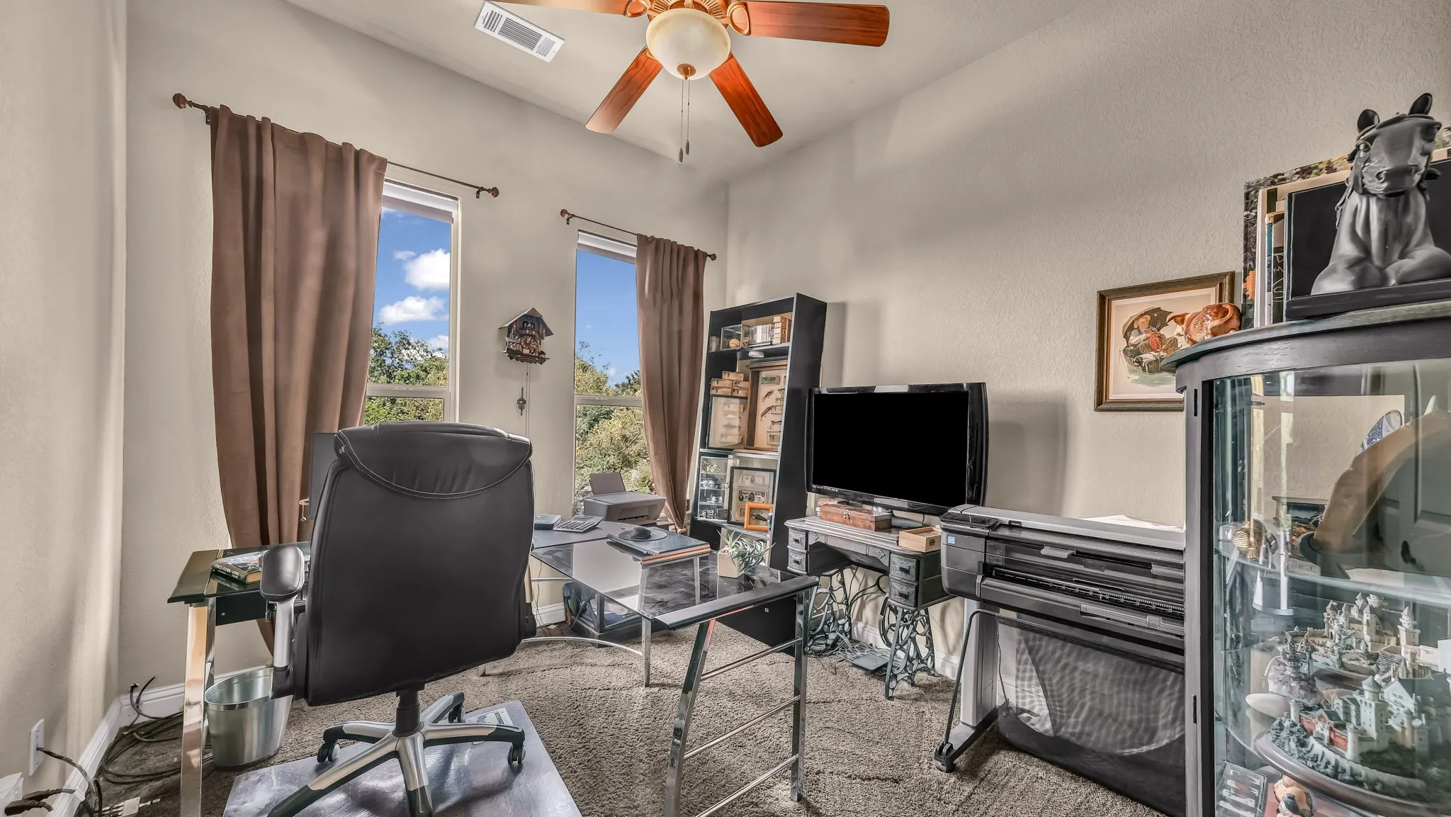 Home office with visible vents and ceiling fan