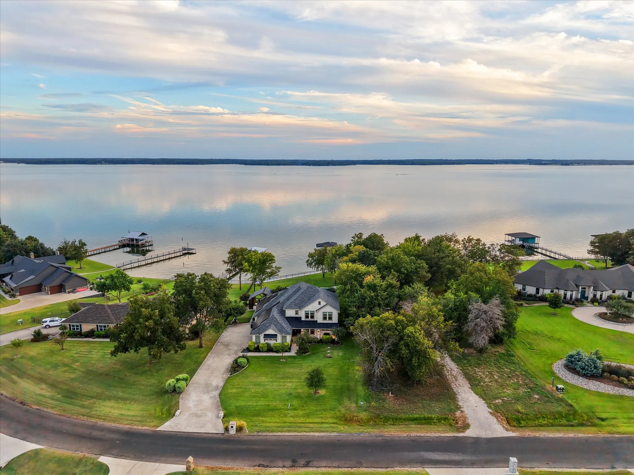 An elevated view captures the home’s inviting curb appeal, set against open water and a wide Texas sky.