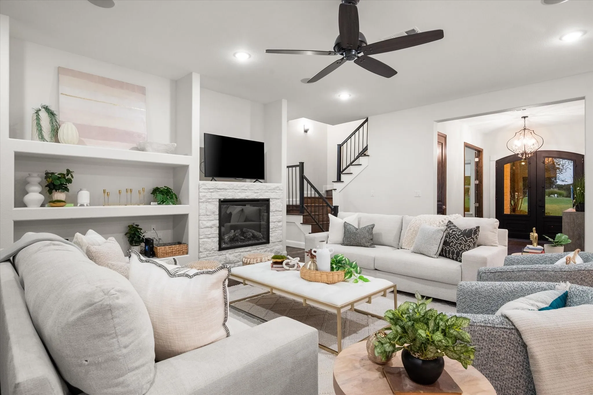 Step inside the open-concept living area, which features a cozy stone fireplace and built-in shelving.