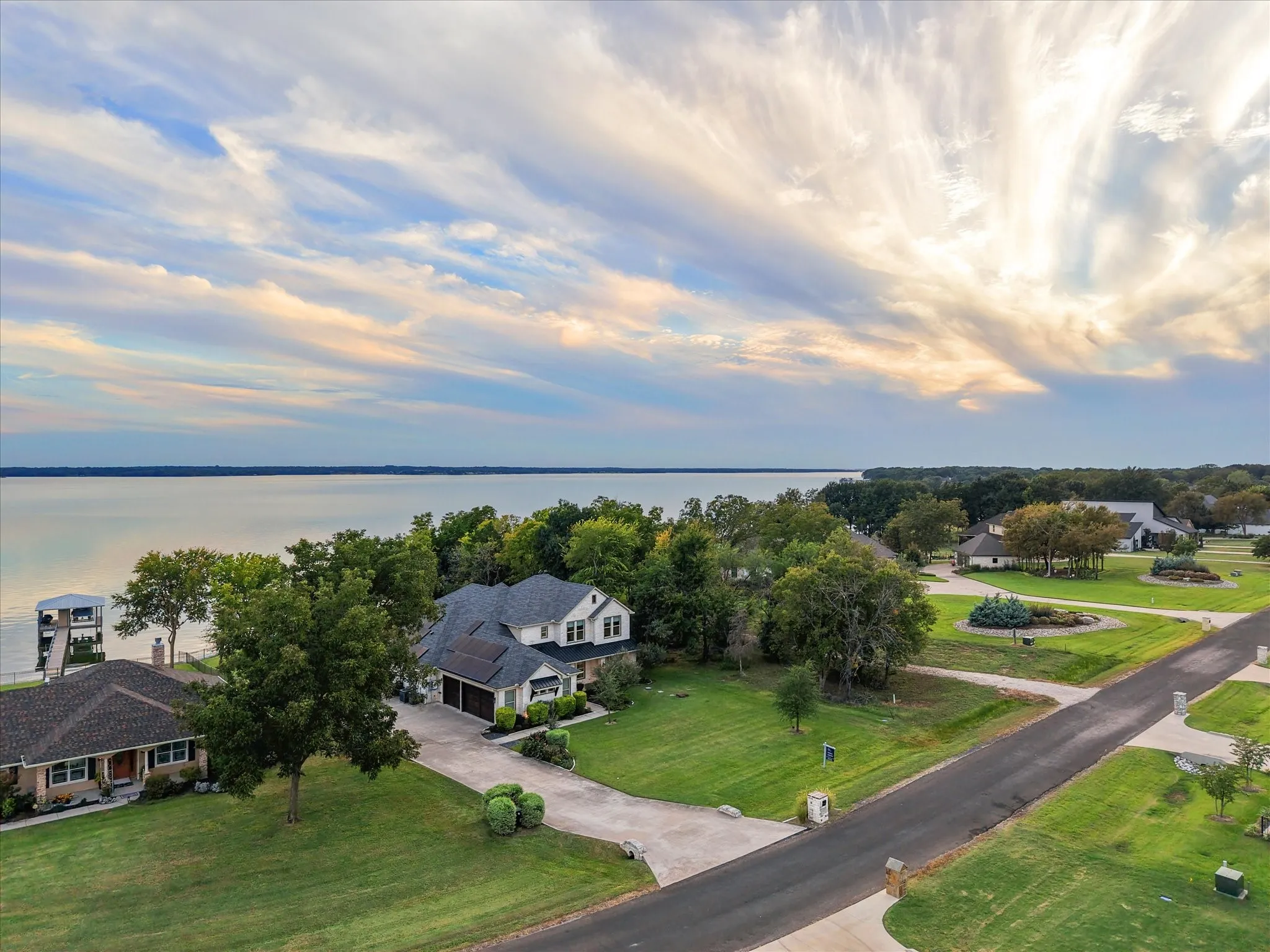 The front of the home is framed by lake and sky, completing the portrait of a true Texas lakefront retreat.