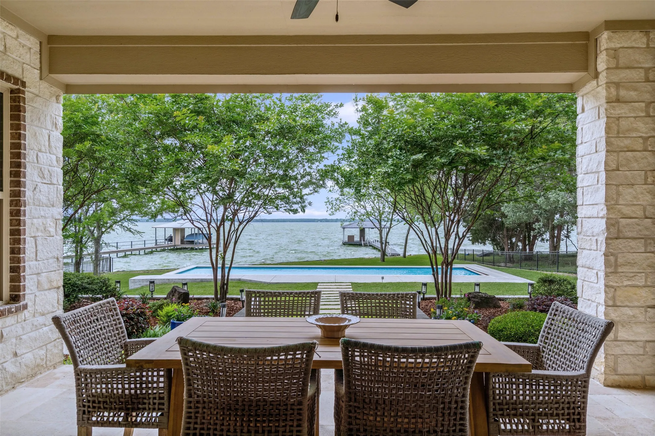 Enjoy al fresco dining on the covered patio, where the pool and lake provide a stunning backdrop.