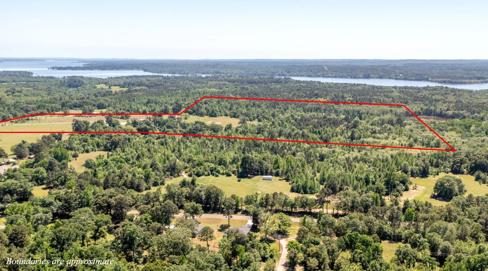Birds eye view of property featuring a water view and a view of trees