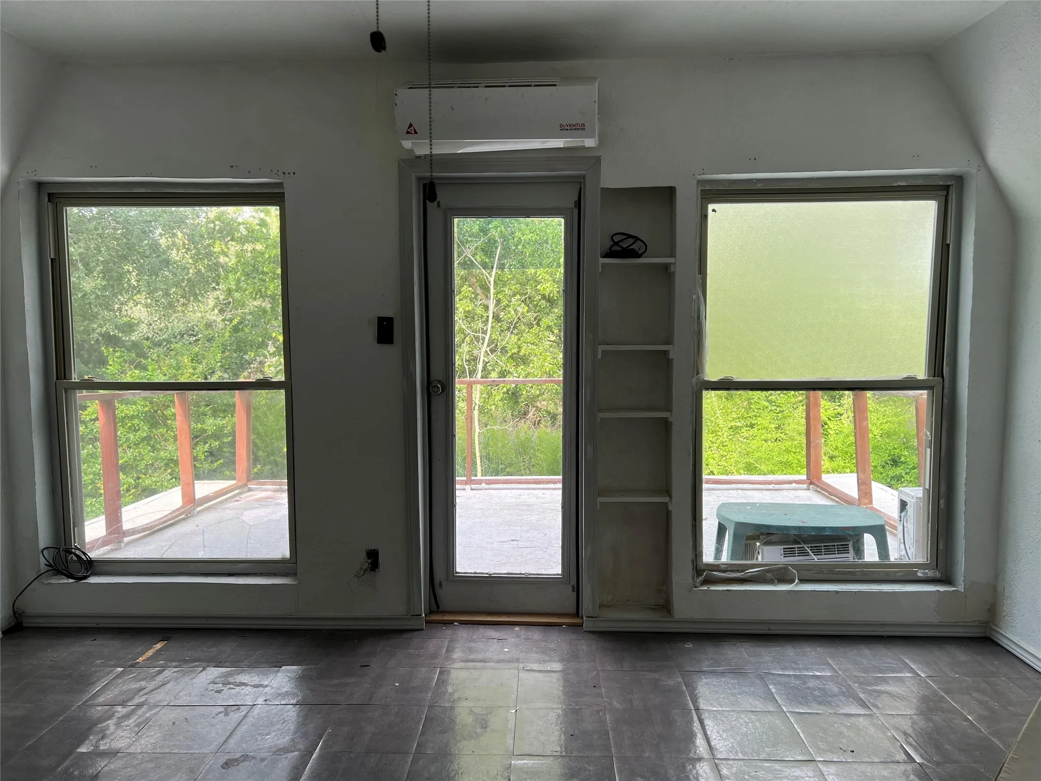 Doorway to outside featuring stone tile floors and a wall mounted air conditioner