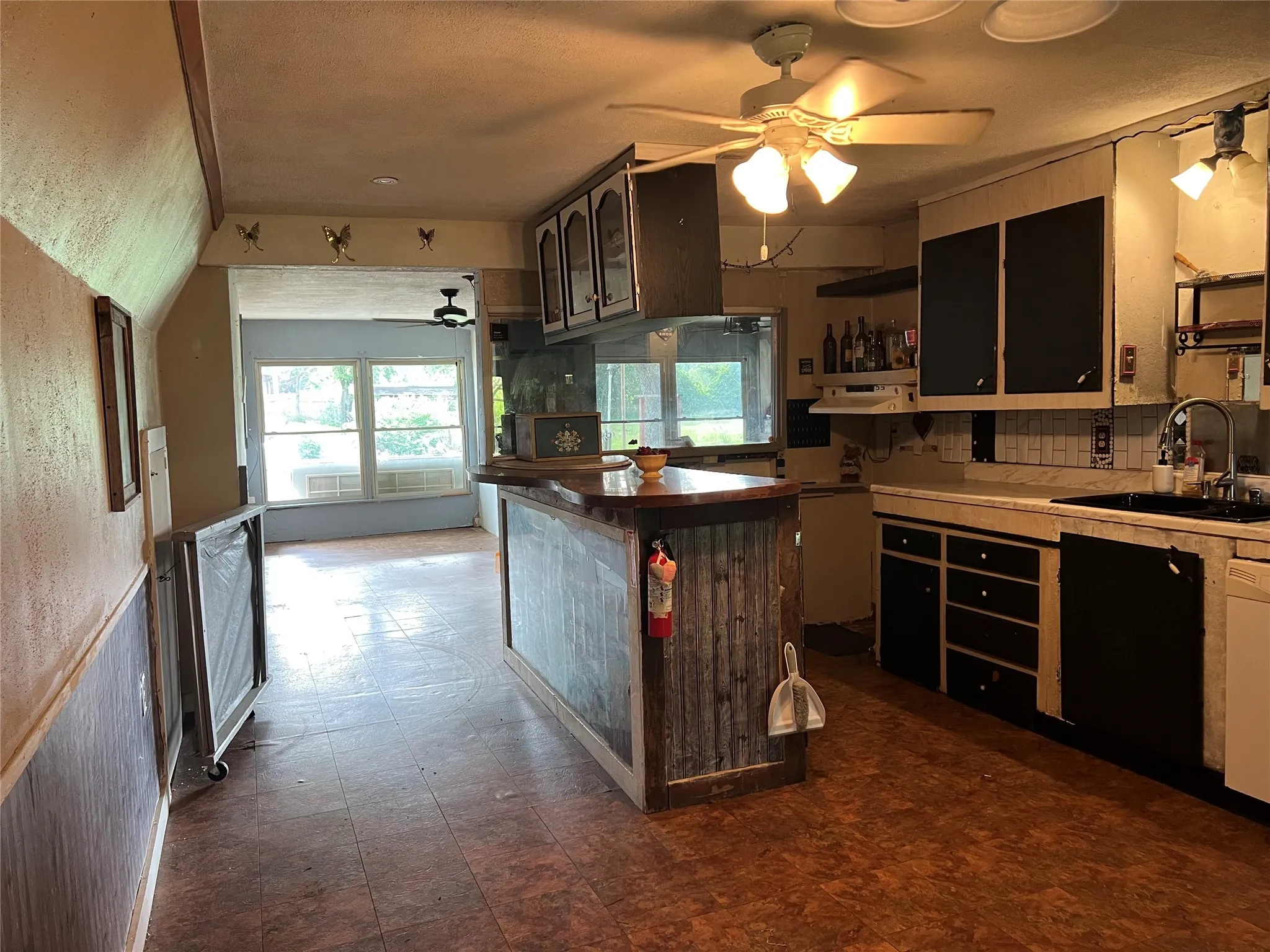 Kitchen with a ceiling fan, open shelves, backsplash, and dark floors