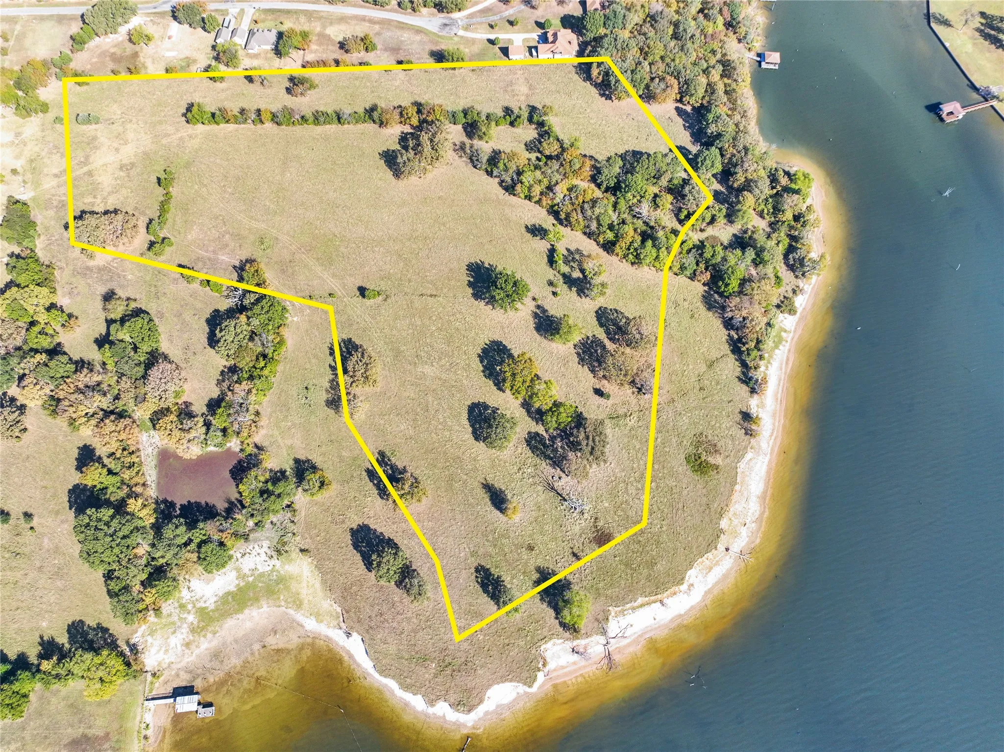 Aerial view of property's location featuring property parcel outlined and a large body of water