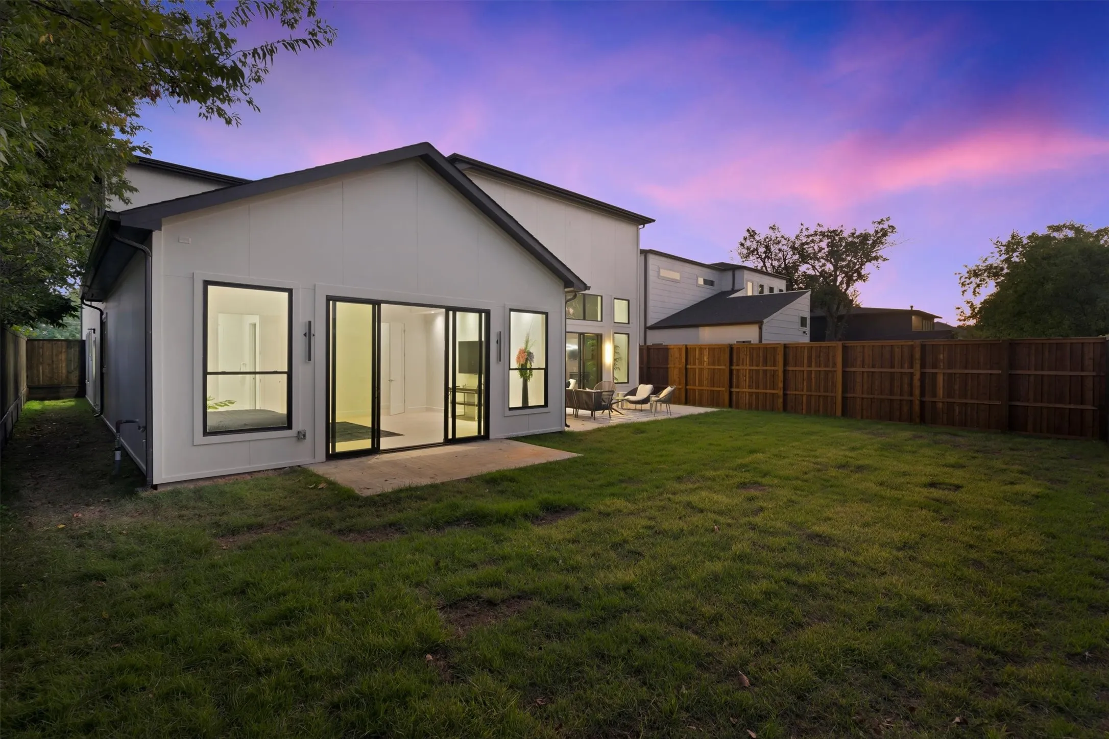Back of property at dusk with a patio