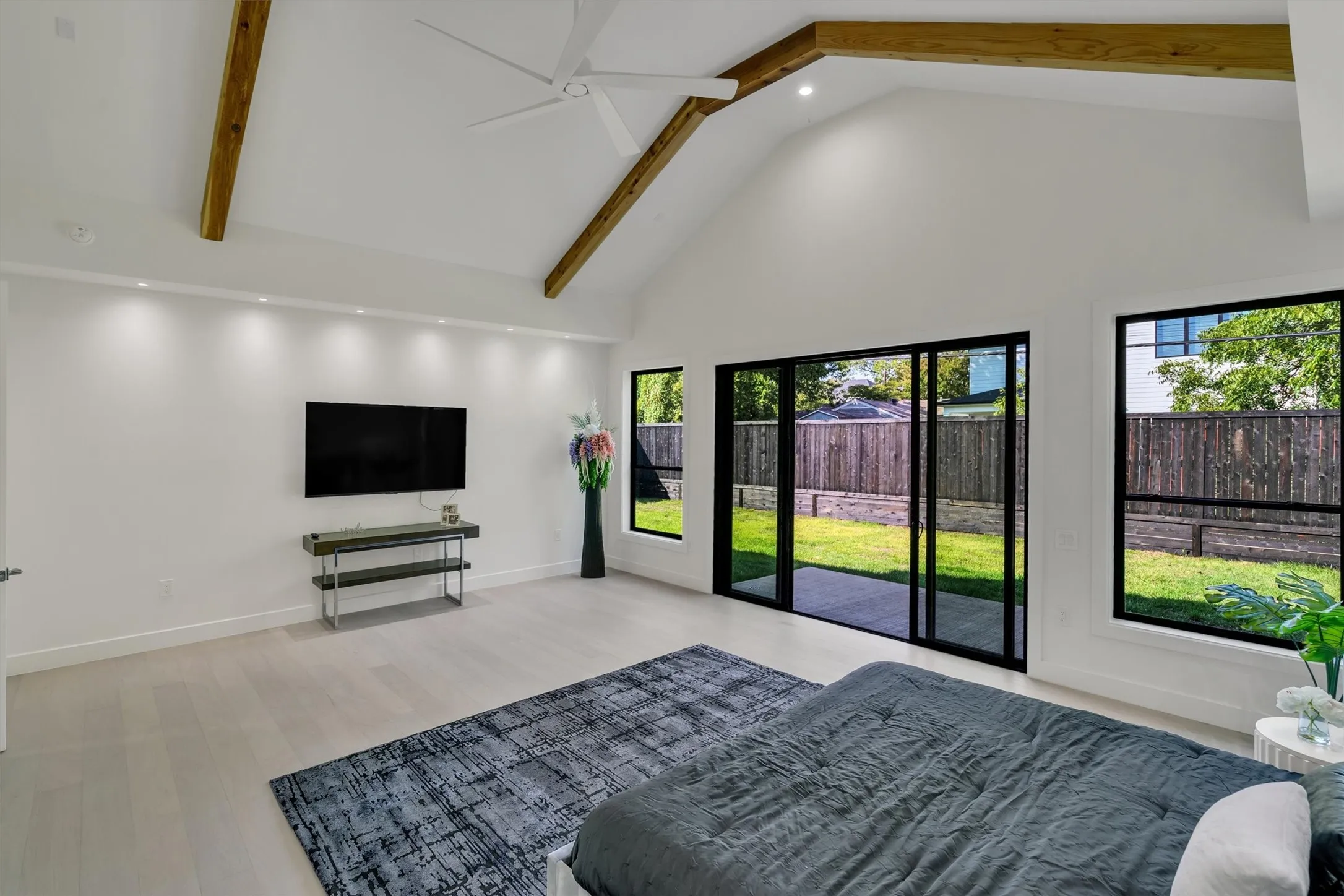 Unfurnished bedroom featuring high vaulted ceiling, access to outside, beam ceiling, light wood-type flooring, and recessed lighting