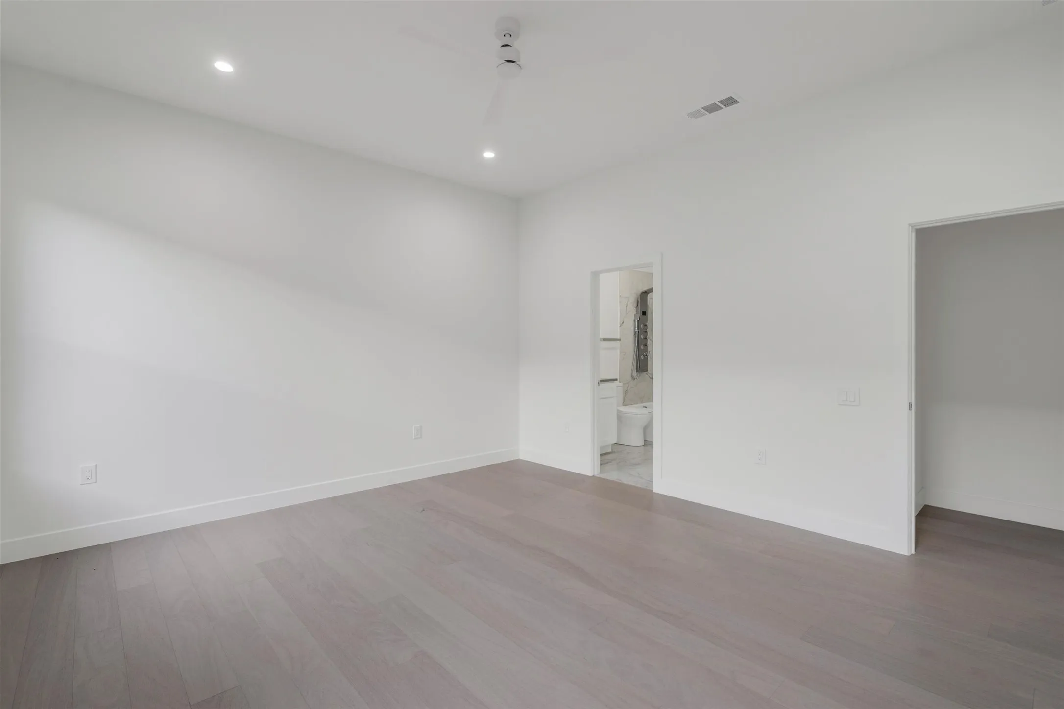 Spare room with wood finished floors, recessed lighting, and baseboards