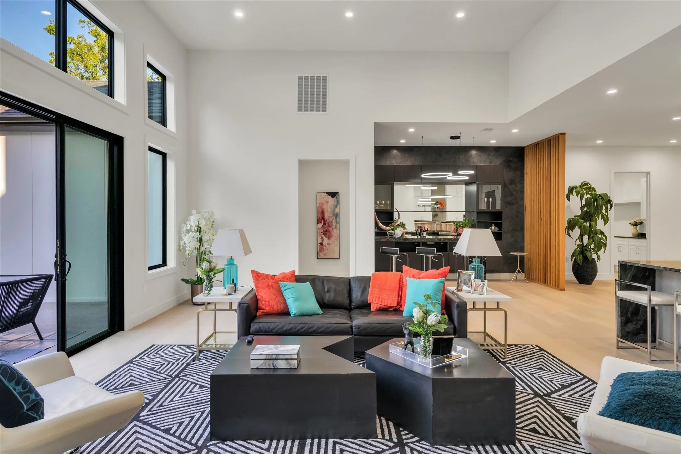 Living area with a towering ceiling, healthy amount of natural light, recessed lighting, and light wood-style floors
