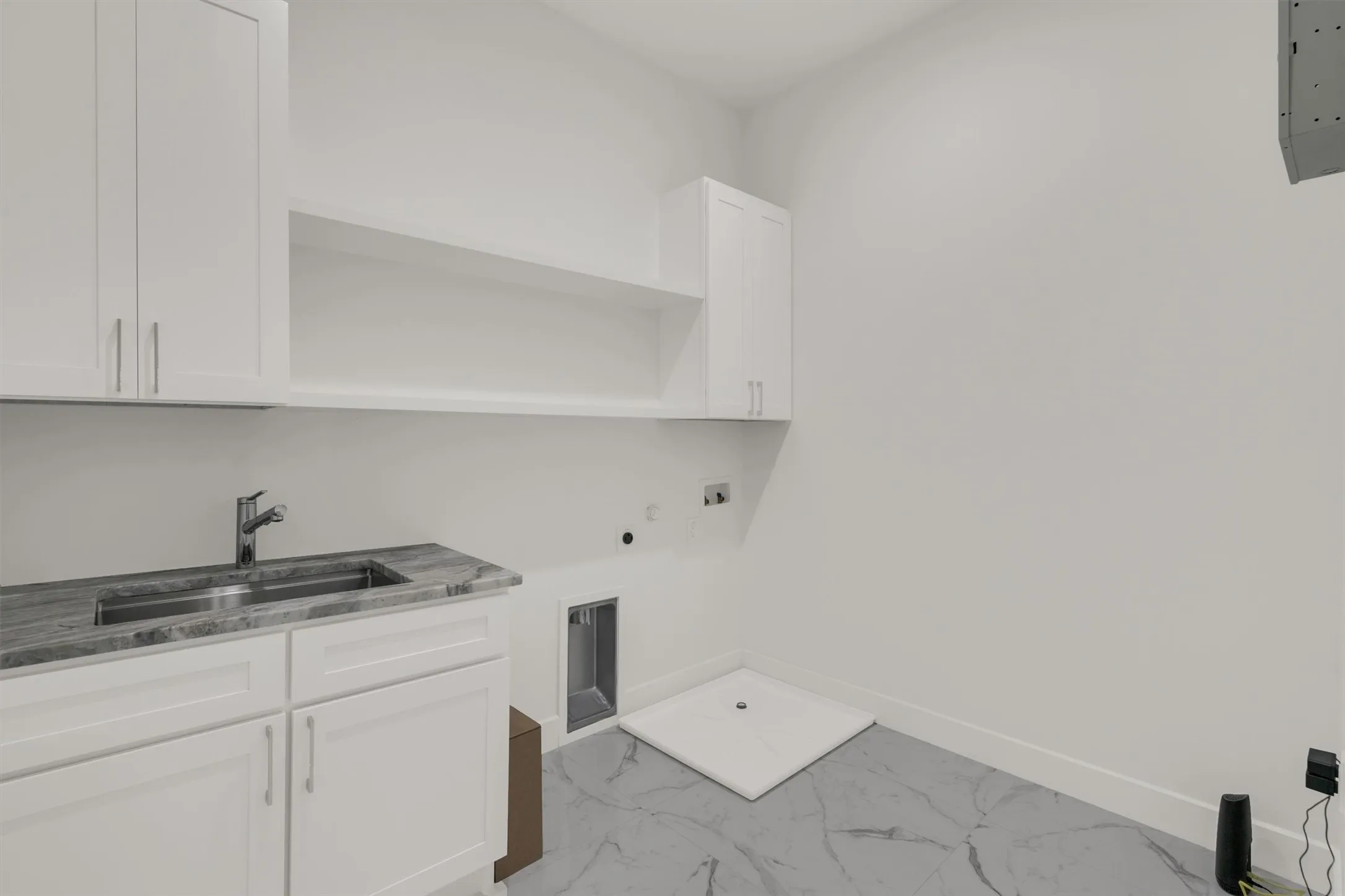 Clothes washing area with hookup for an electric dryer, cabinet space, gas dryer hookup, baseboards, and electric panel