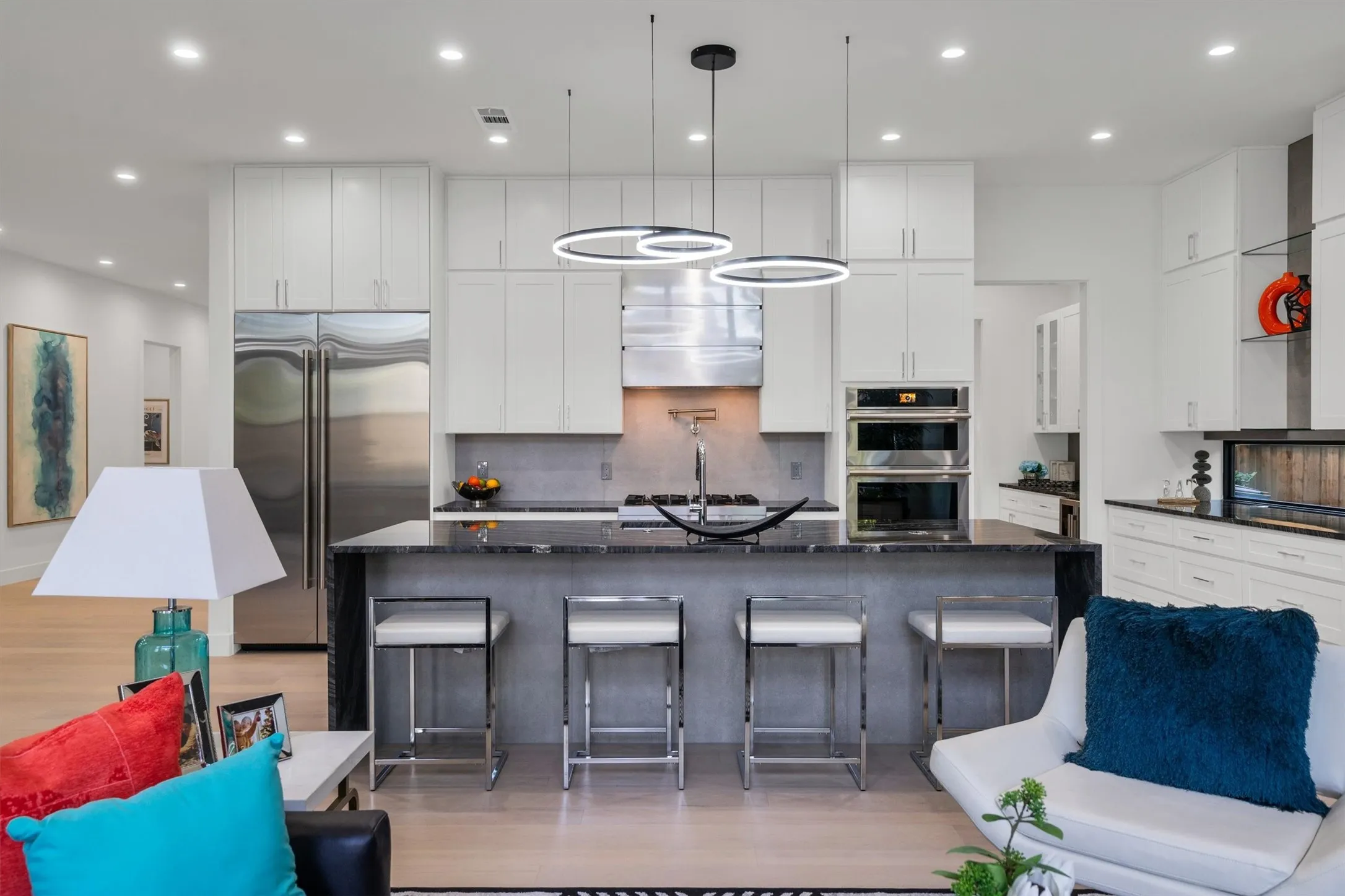 Kitchen with appliances with stainless steel finishes, light wood-type flooring, decorative backsplash, a kitchen breakfast bar, and recessed lighting