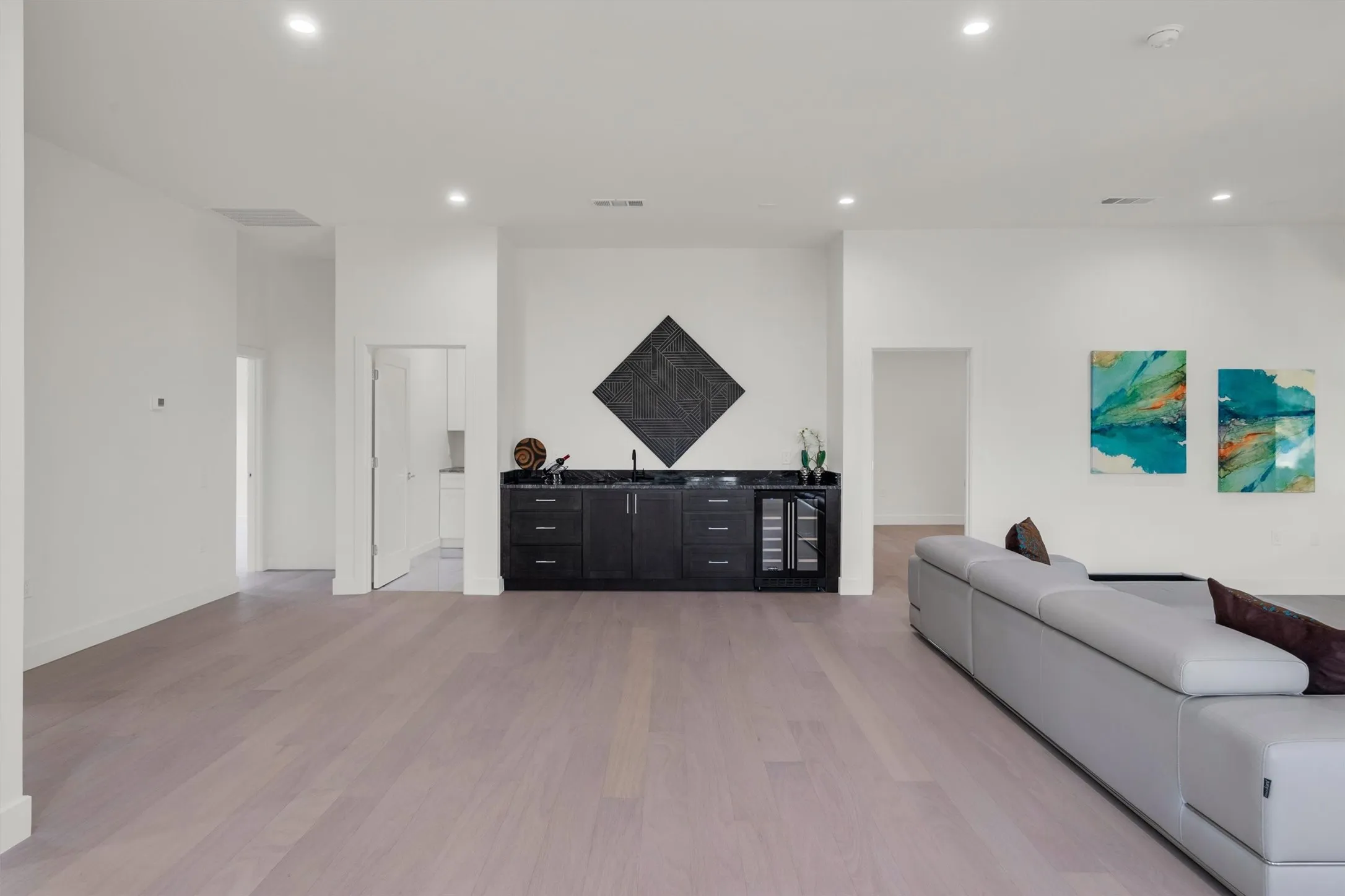 Living room with recessed lighting, light wood-style floors, beverage cooler, a dry bar, and baseboards