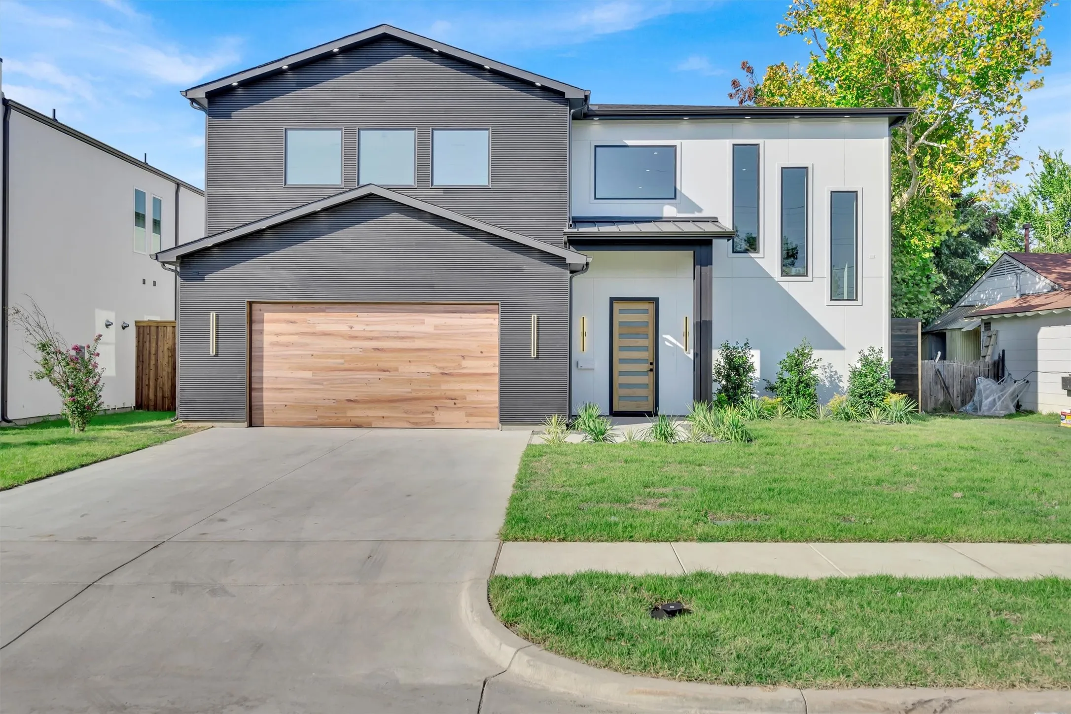 Contemporary house featuring concrete driveway, metal roof, and a standing seam roof