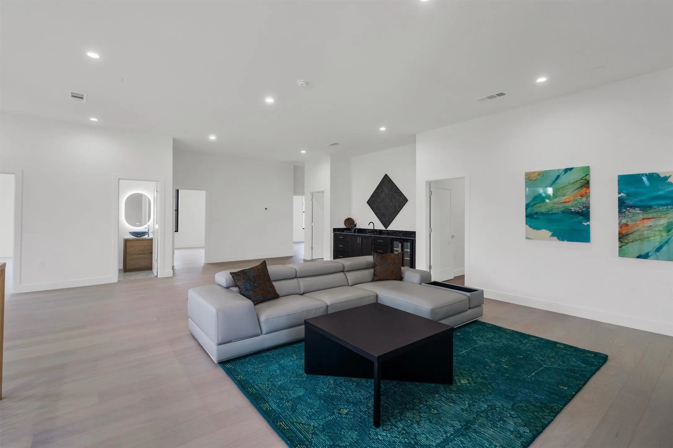 Living area with light wood-style floors, recessed lighting, a bar, and baseboards