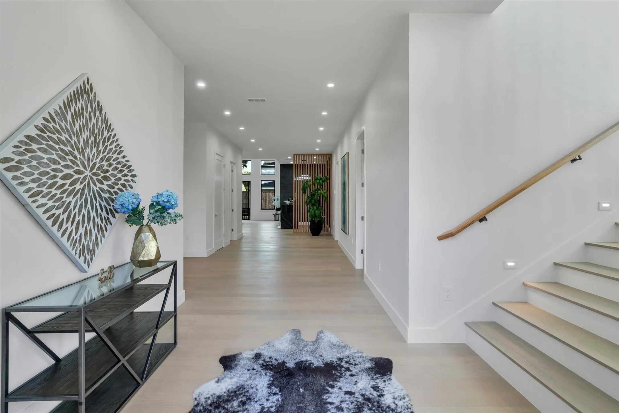 Hallway featuring light wood-style floors, stairway, recessed lighting, and baseboards