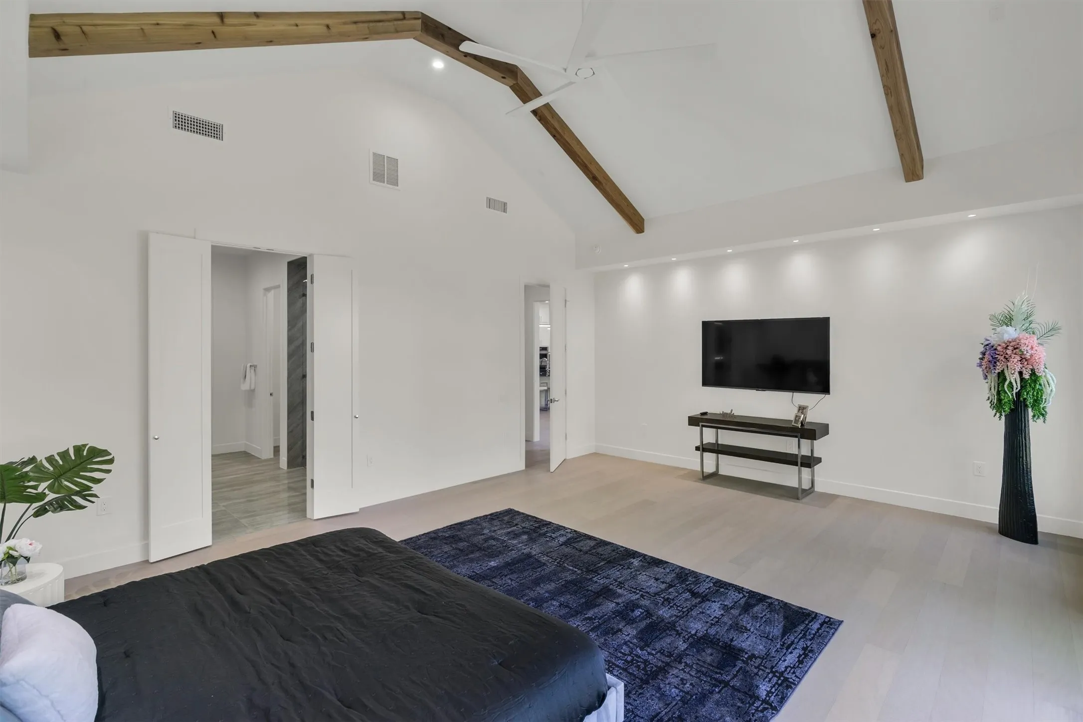 Bedroom featuring high vaulted ceiling, light wood-type flooring, baseboards, recessed lighting, and beamed ceiling