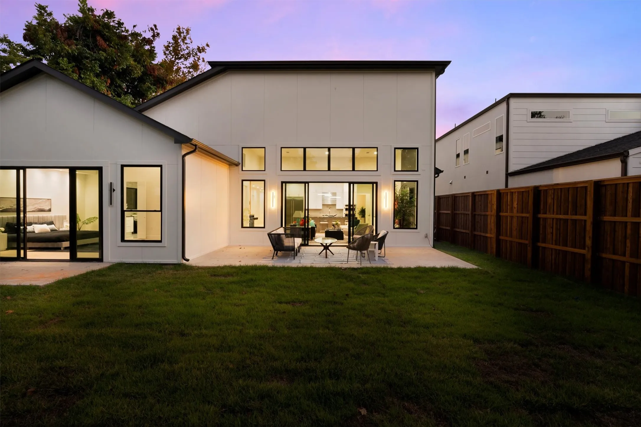Back of property at dusk featuring a patio and an outdoor living space