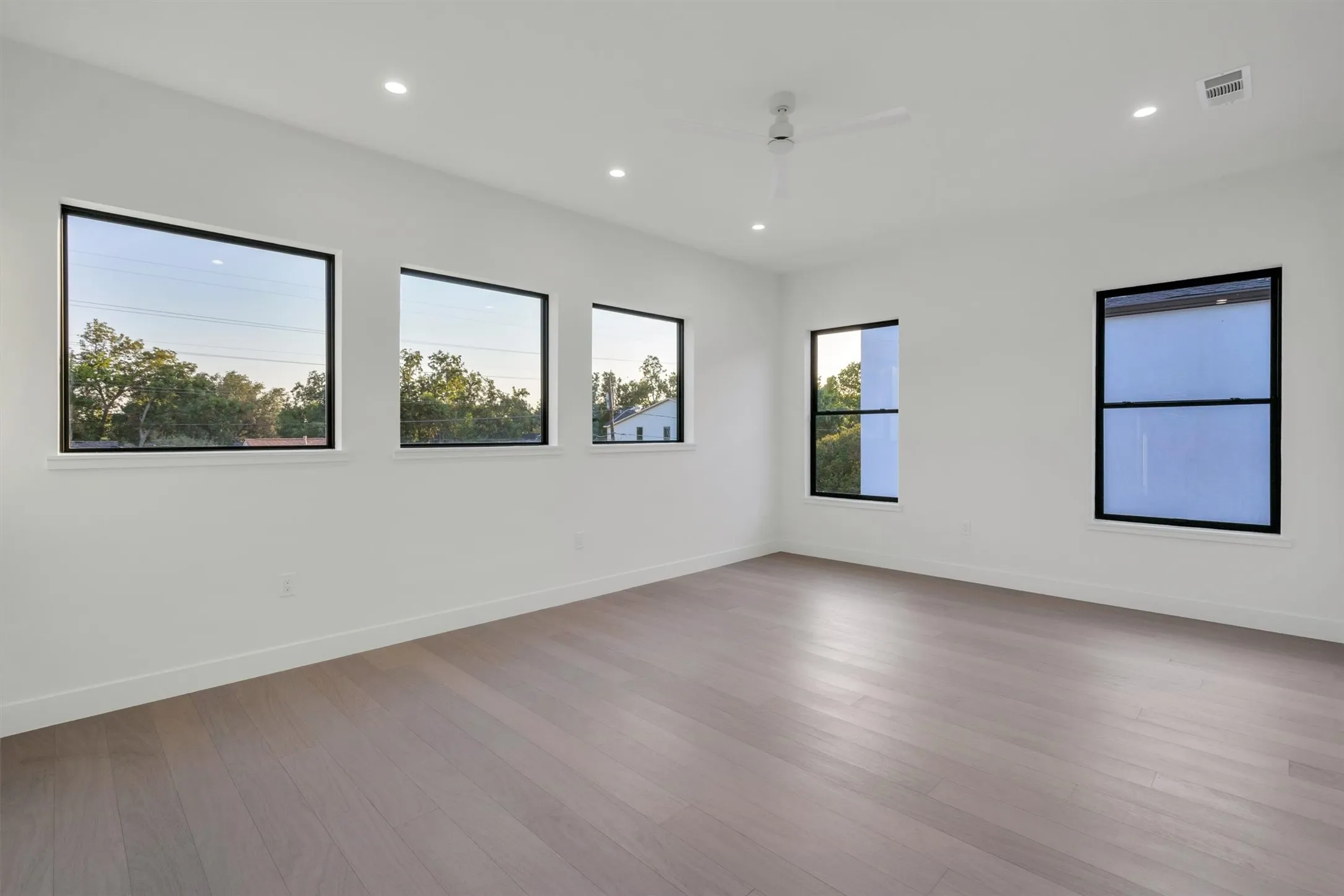 Empty room featuring ceiling fan, wood finished floors, recessed lighting, and baseboards