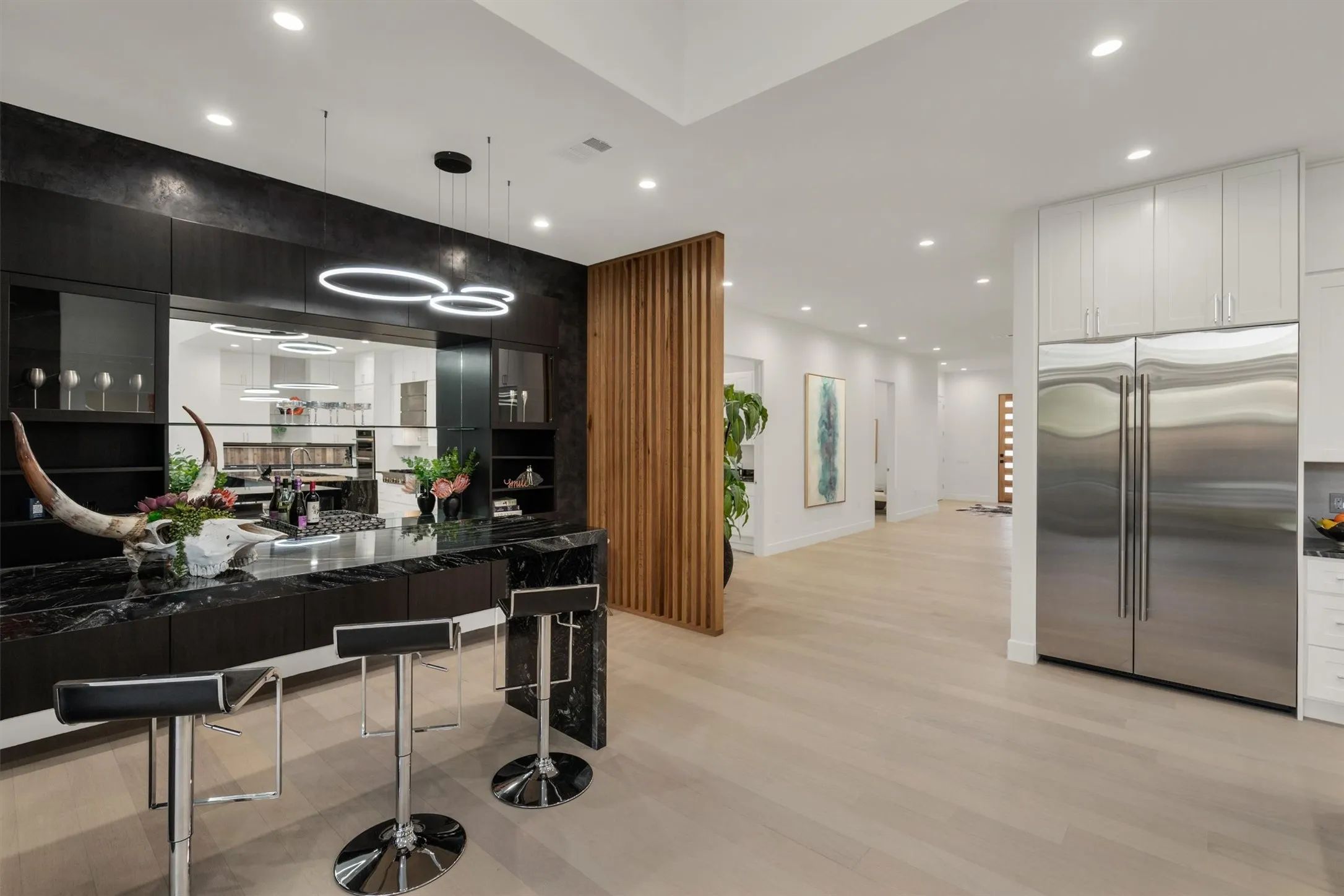 Kitchen with high quality fridge, light wood-style flooring, recessed lighting, white cabinets, and decorative light fixtures