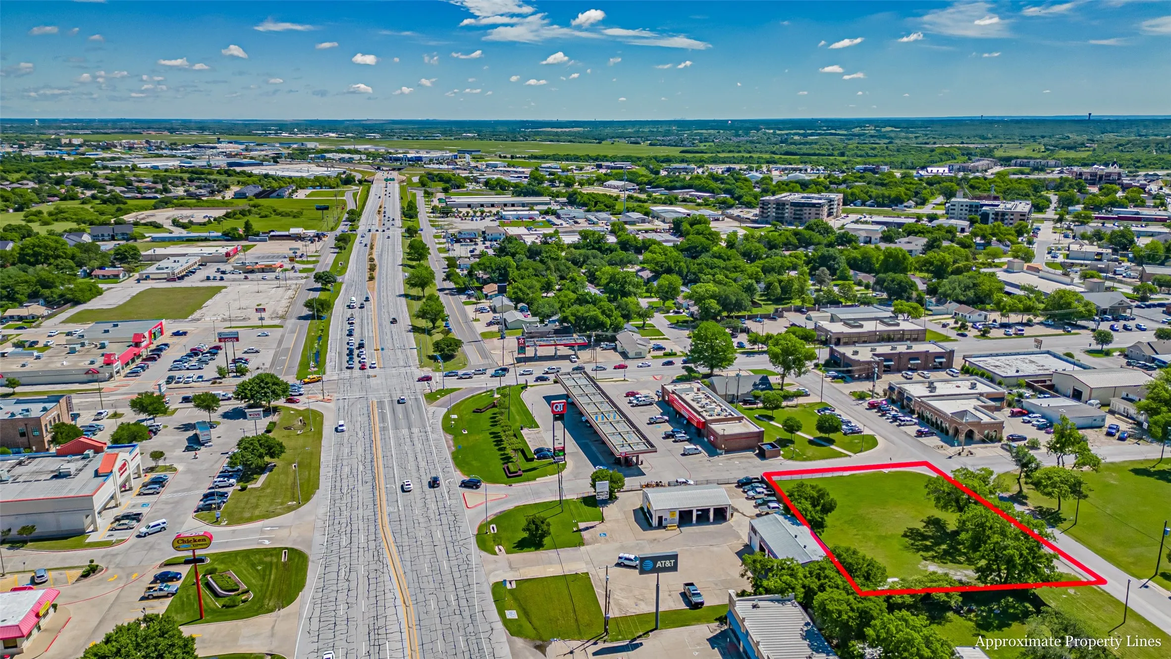 Aerial view of property and surrounding area featuring property boundaries highlighted and a highway