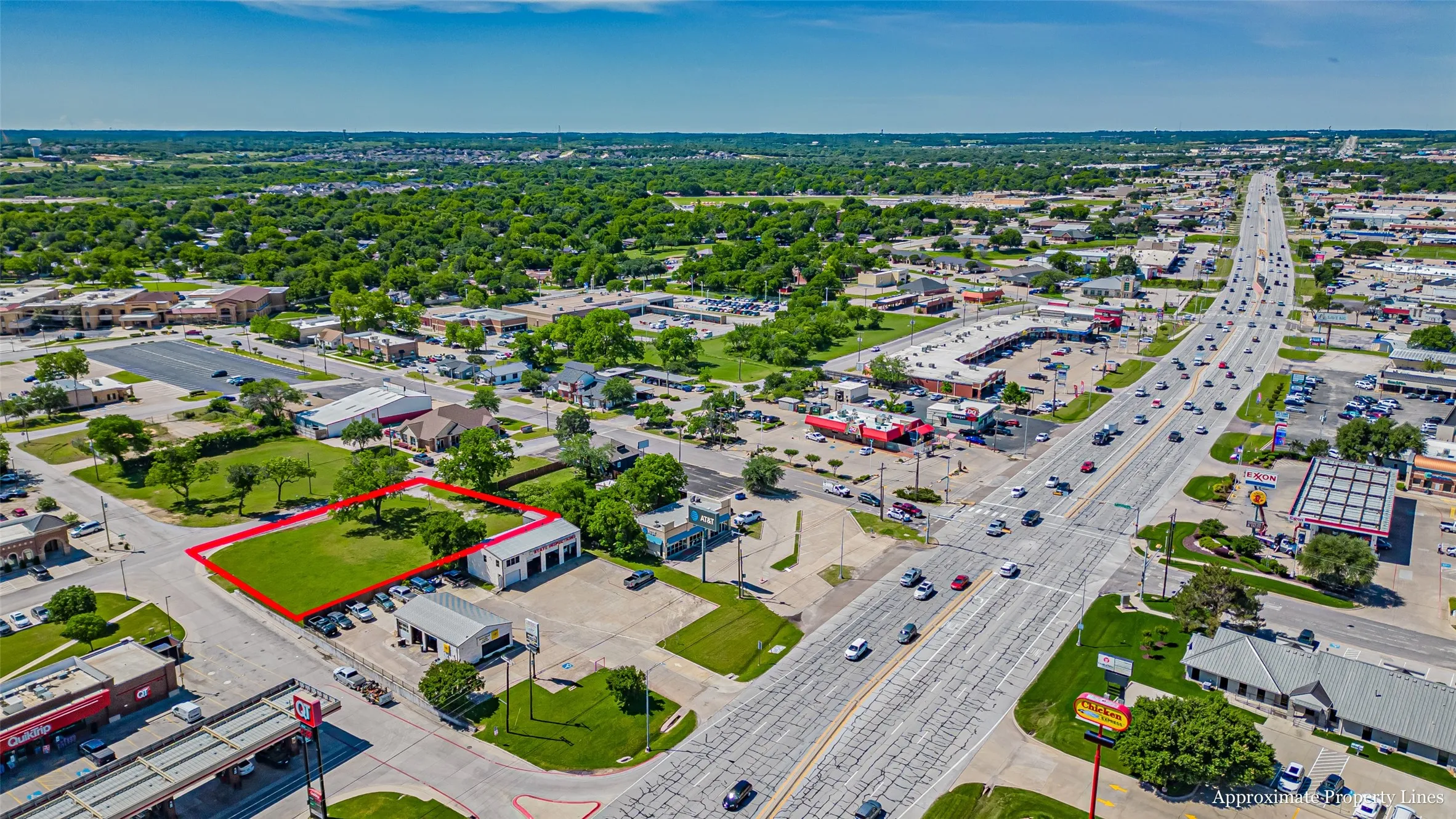 Aerial overview of property's location with property parcel outlined and a main thoroughfare