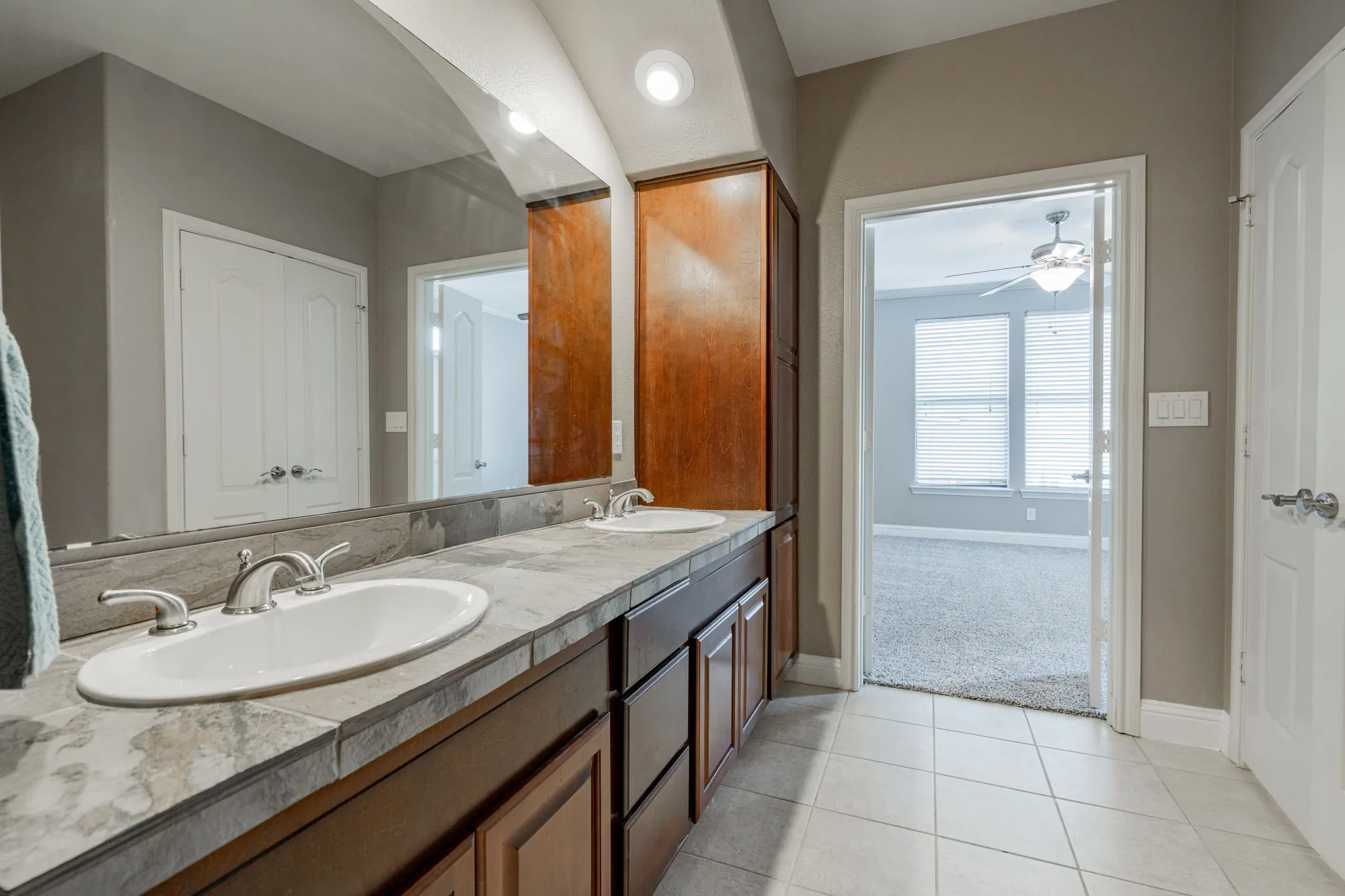 Full bath with baseboards, tile patterned floors, double vanity, and ceiling fan